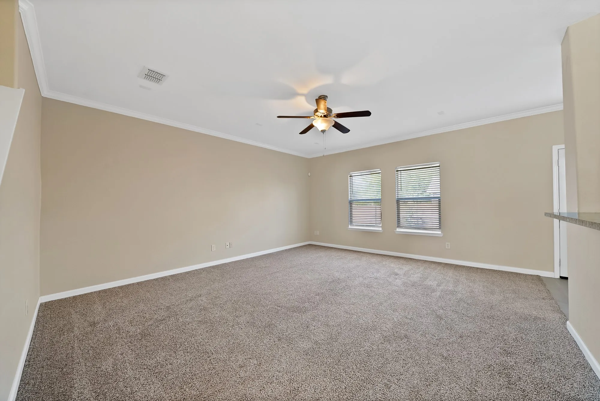Spare room featuring carpet flooring, ceiling fan, and ornamental molding