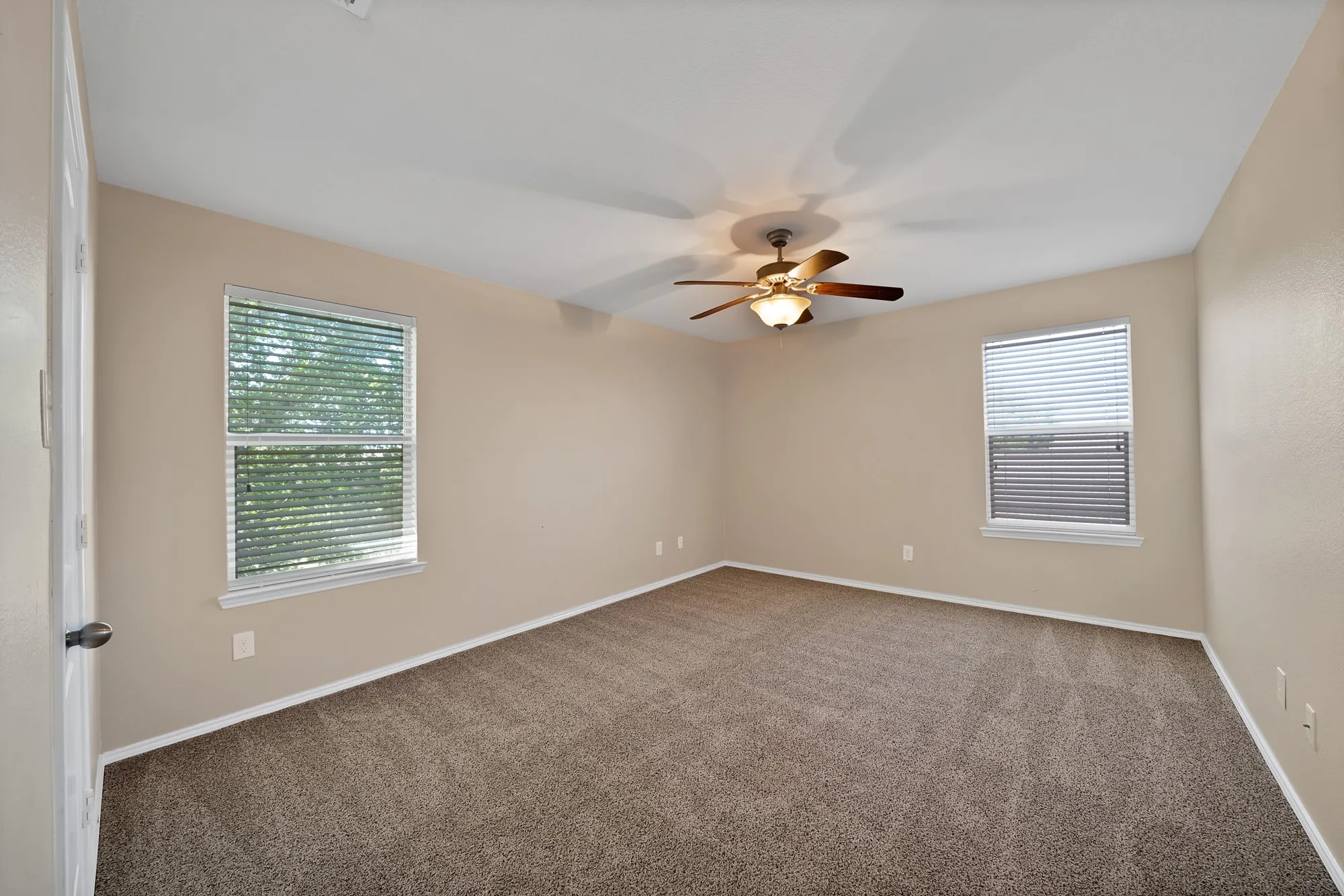 Spare room with dark carpet and a ceiling fan