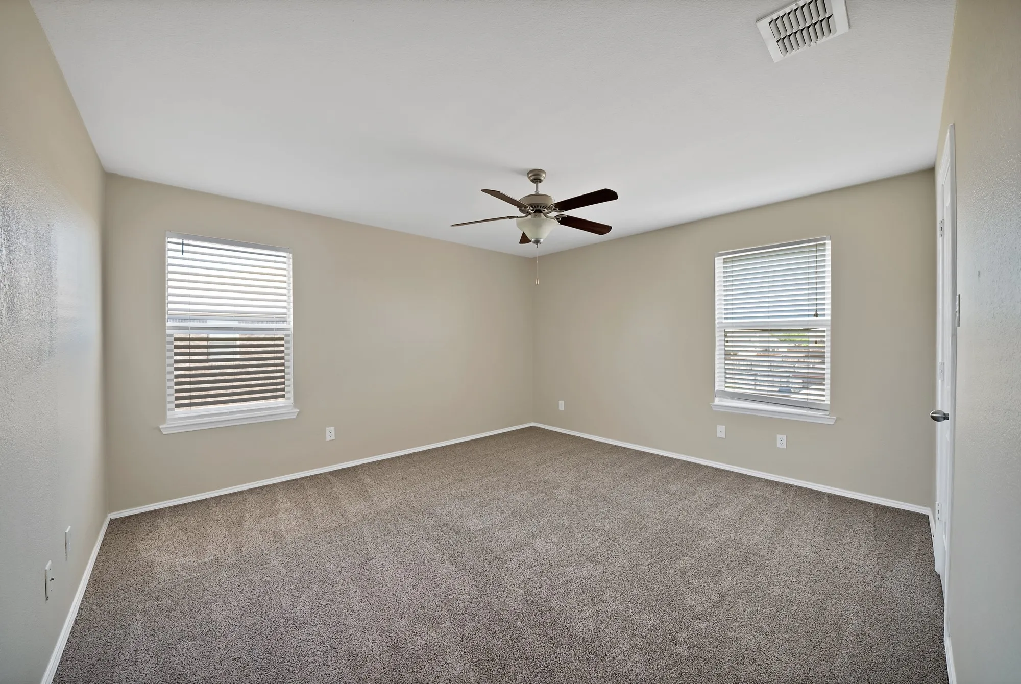 Unfurnished room with dark carpet and ceiling fan