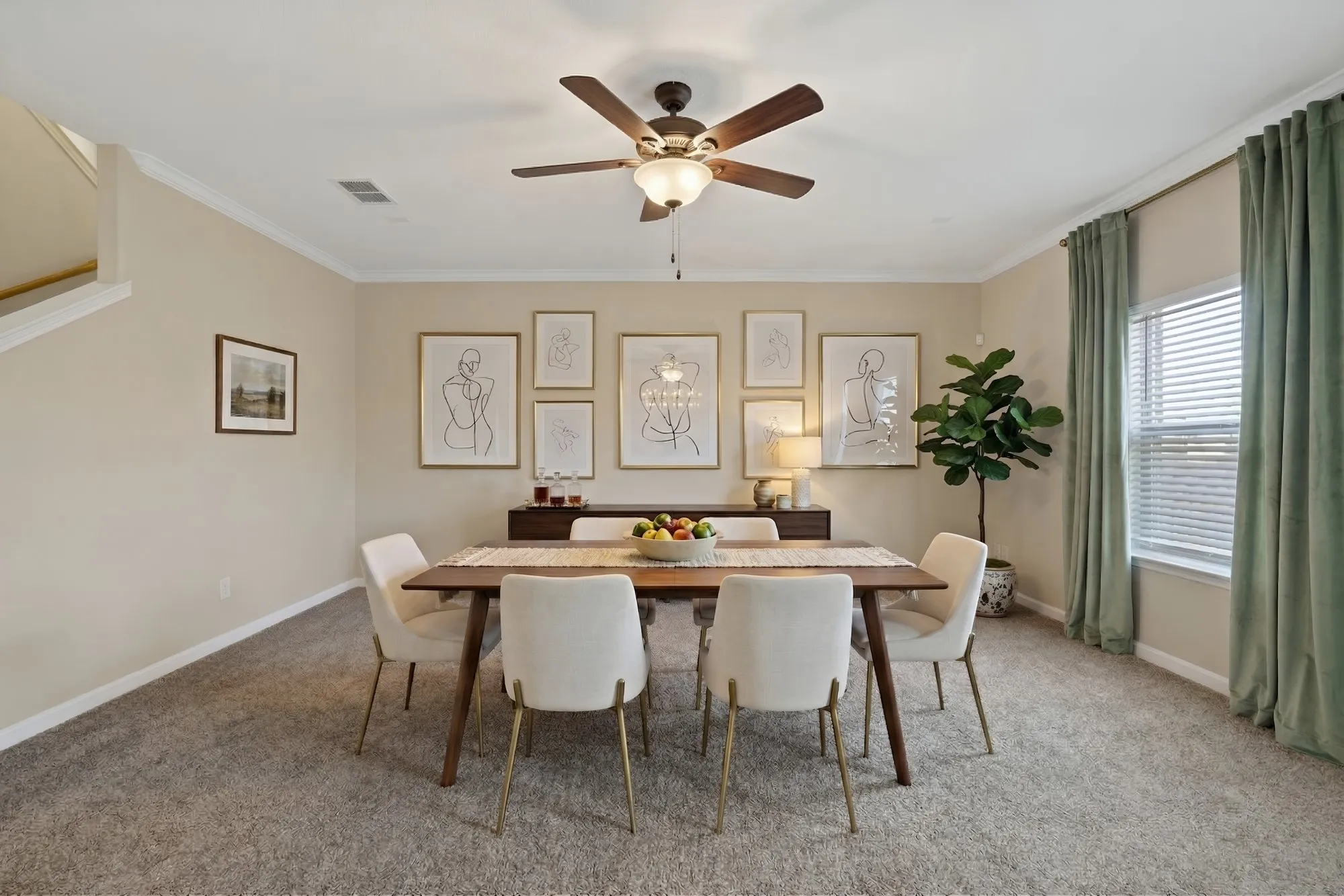Dining space with ceiling fan, light colored carpet, and crown molding