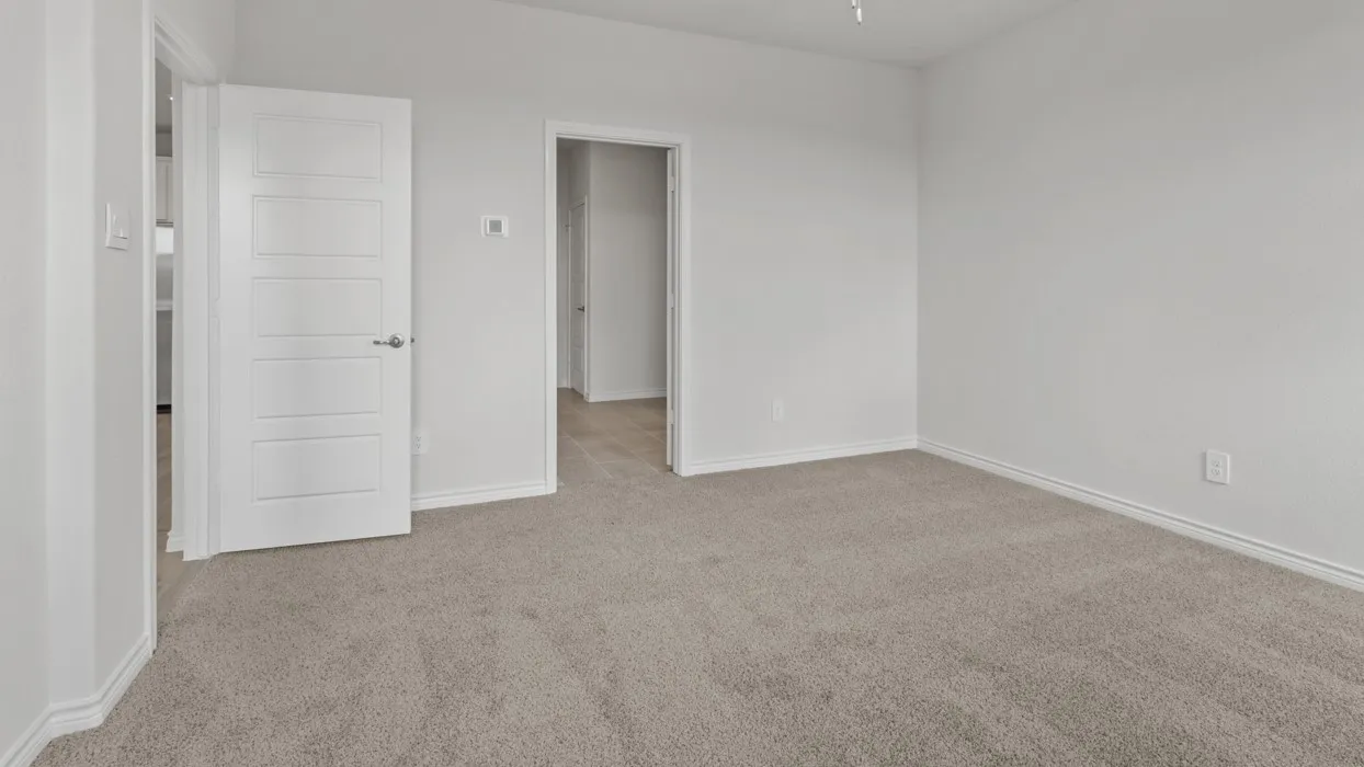 Unfurnished bedroom featuring light colored carpet and baseboards