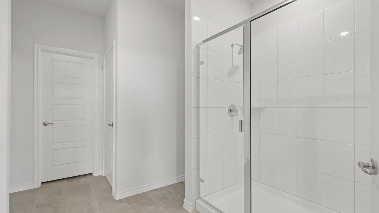 Bathroom with a stall shower and light tile patterned floors