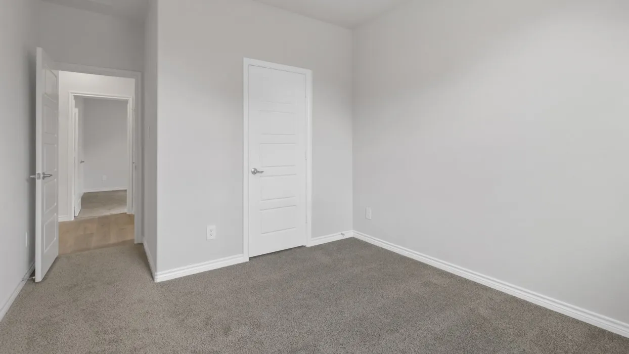 Unfurnished bedroom featuring dark colored carpet and baseboards