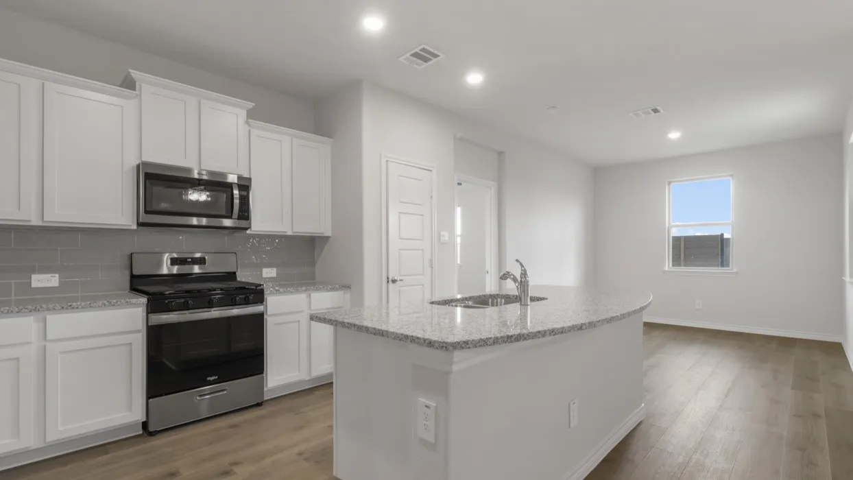 Kitchen with stainless steel appliances, an island with sink, light wood-style flooring, light stone counters, and recessed lighting