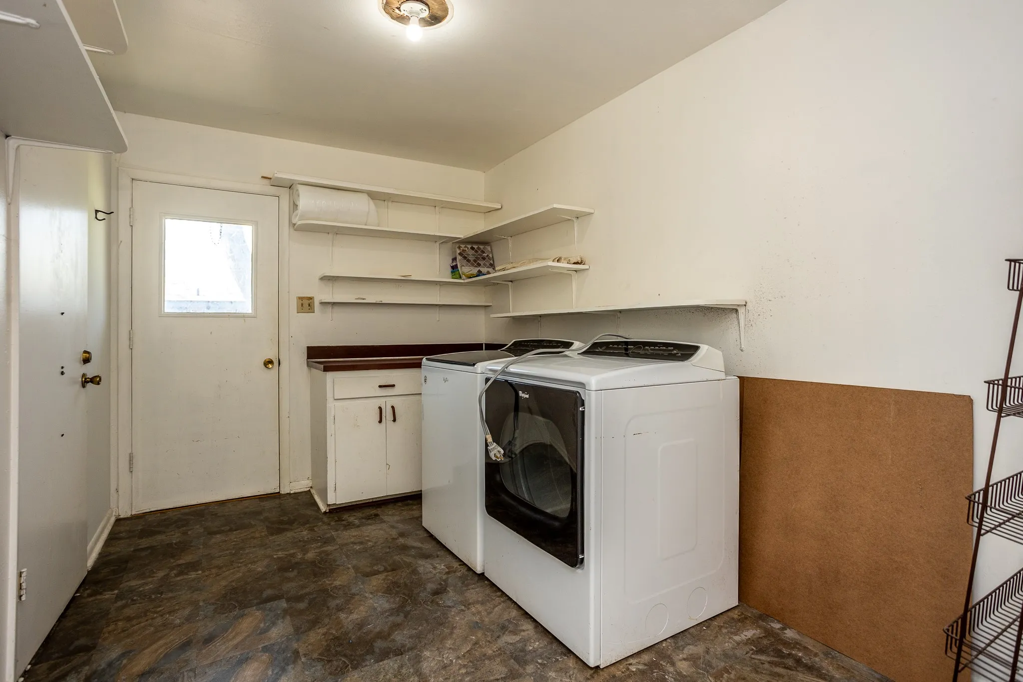 Washer and dryer remain with property.  to the right is a large storage area complete with a workbench and pegwood wall for crafts or hobbies..