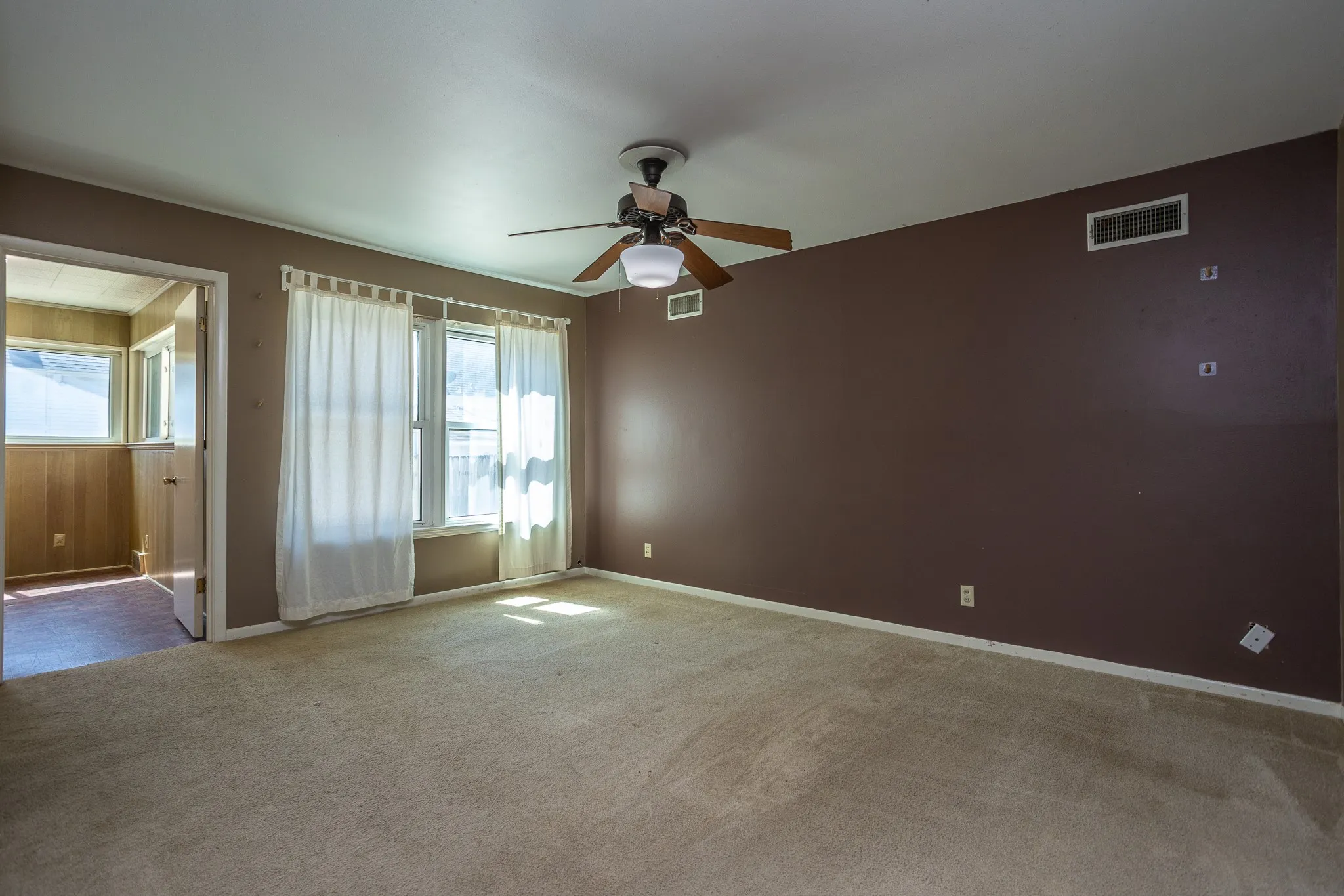 Large Master bedroom has carpet plus a sitting or office space off to the side.