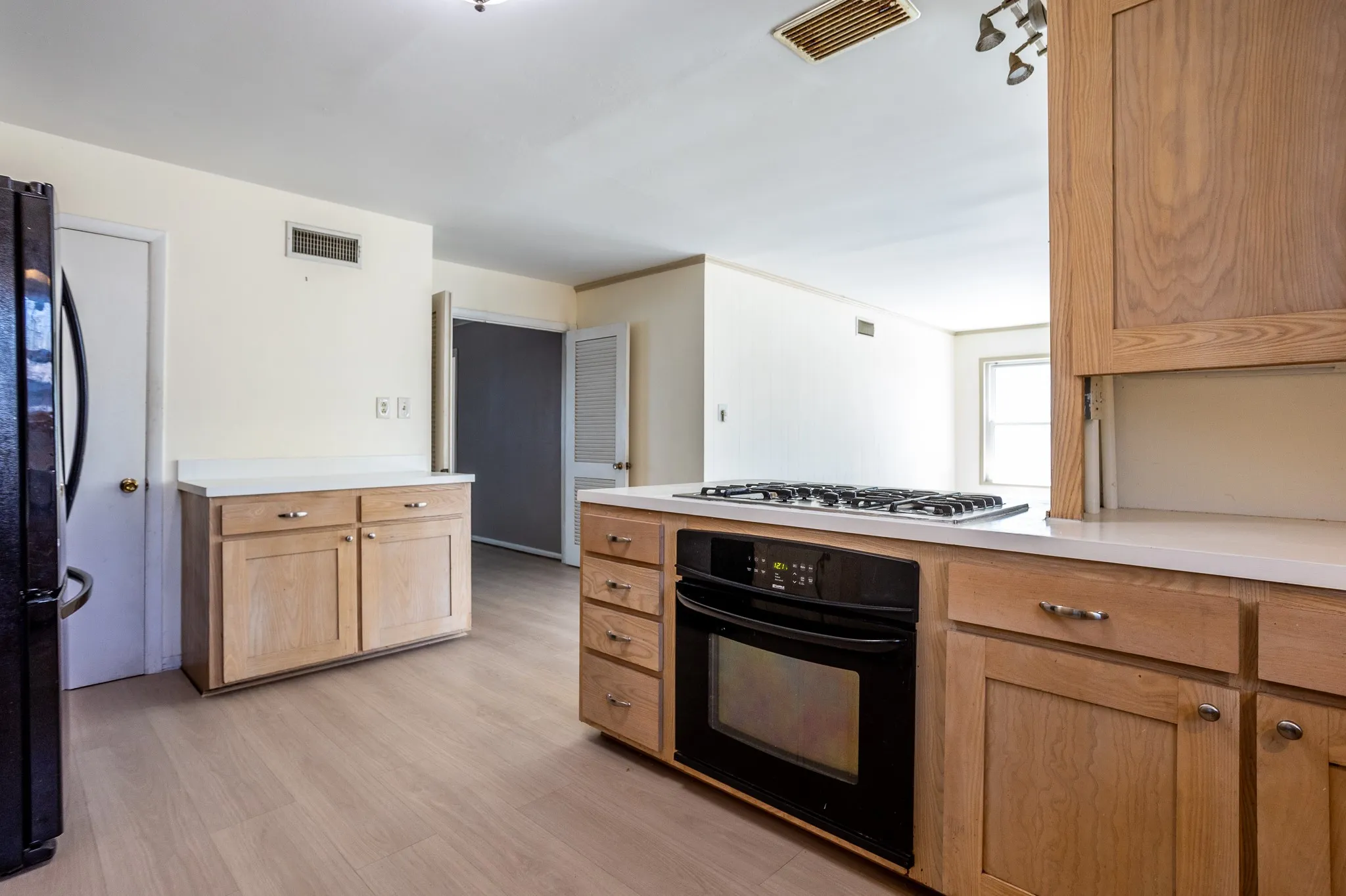 Louvered doors open from front entry .  Kitchen has lots of cabinets and storage