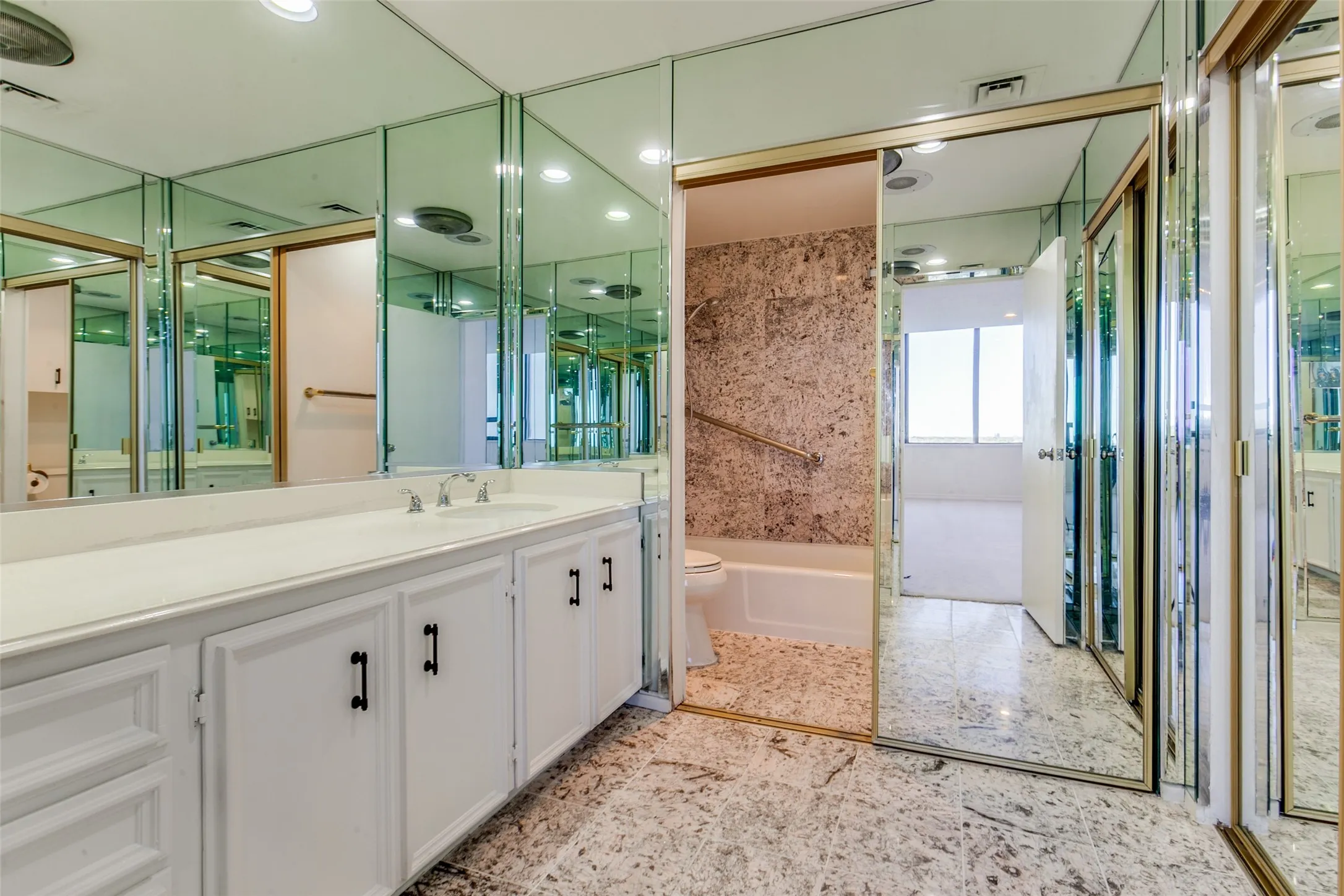 Primary bathroom with full bath with a large walk-in closet. Hand rails are placed in both bathrooms.