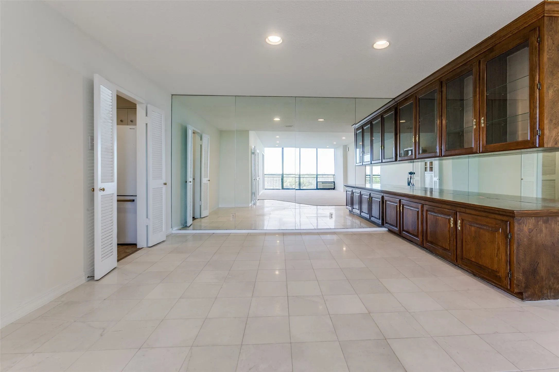 The dining room has a wall of mirrors, stunning built-ins that are lighted on top with glass fronts for display. Storage and wine holder beneath.