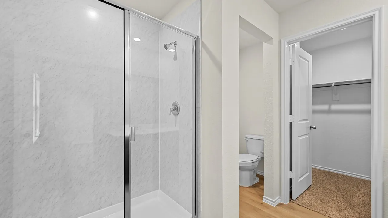 Bathroom with a stall shower, a walk in closet, and light wood finished floors