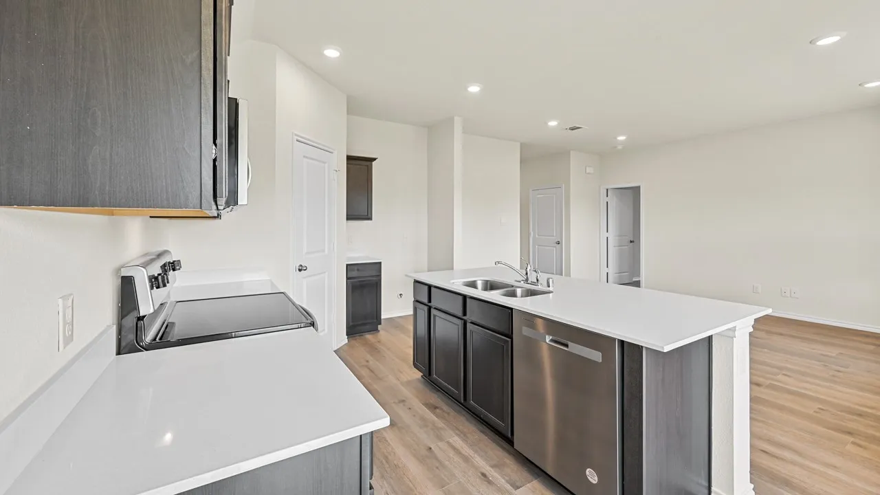 Kitchen with stainless steel appliances, a kitchen island with sink, recessed lighting, light wood-type flooring, and dark wood finish cabinetry