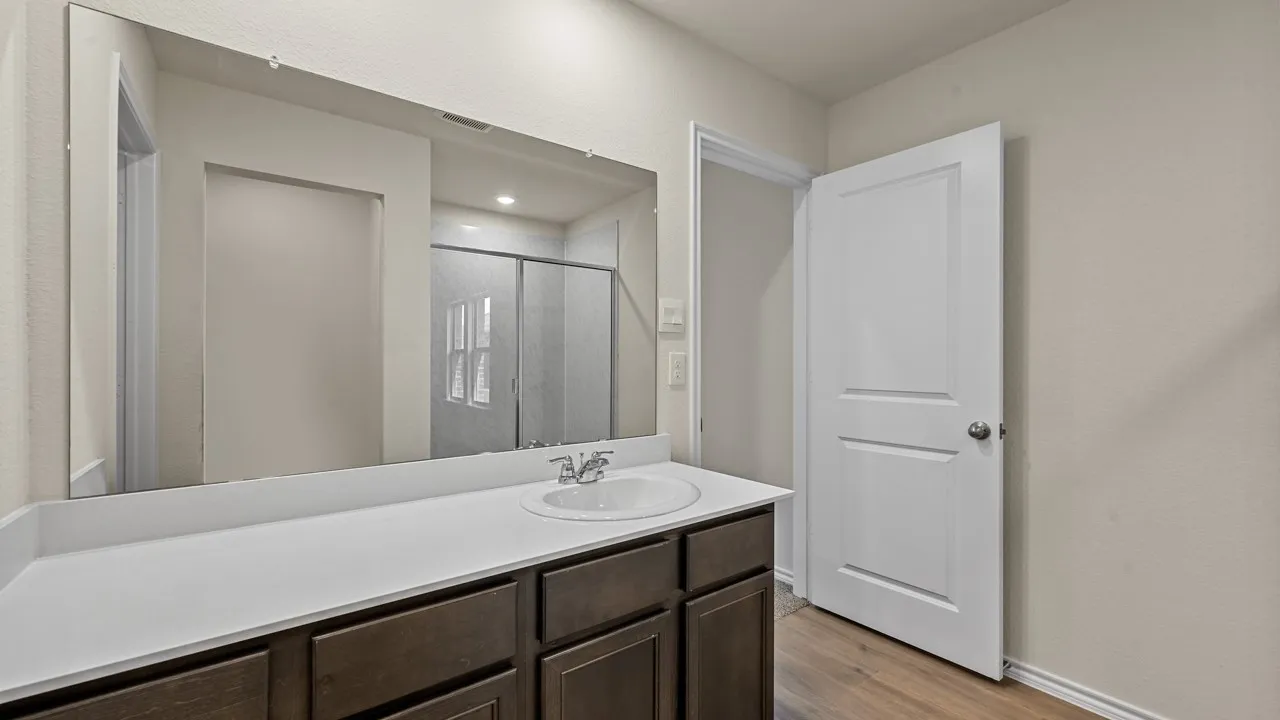 Bathroom featuring vanity, a stall shower, and light wood-type flooring