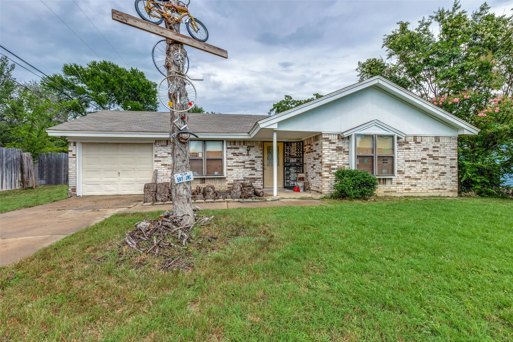 Ranch-style home featuring an attached garage, driveway, and brick siding