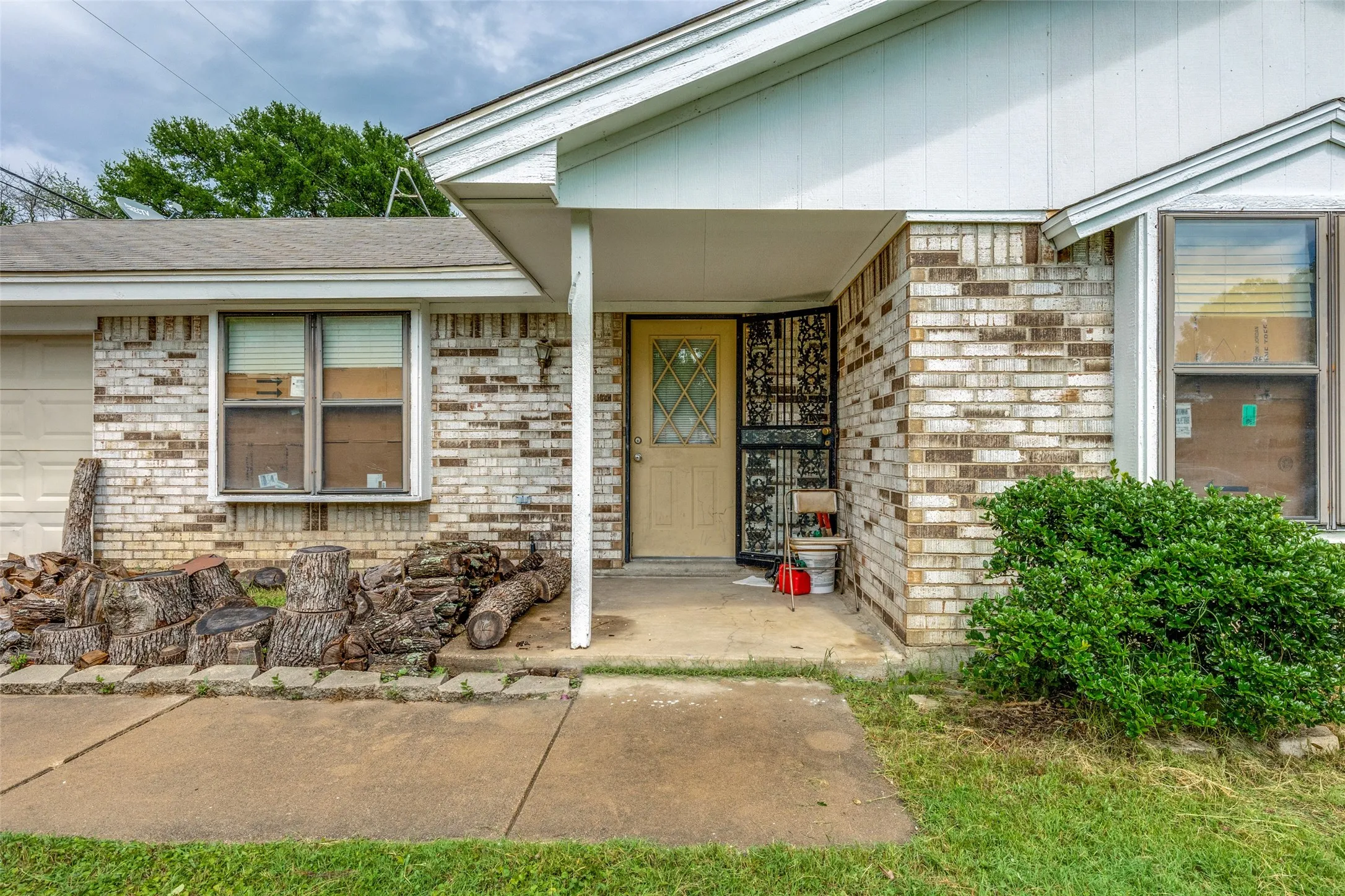 Entrance to property with brick siding and roof with shingles