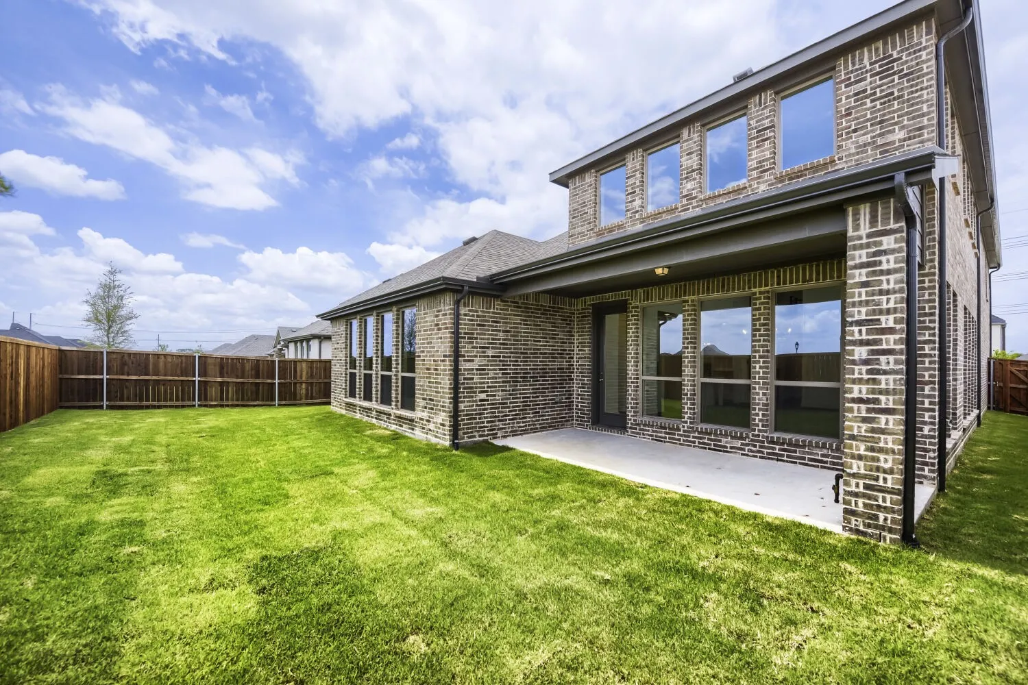 Expansive green lawn with a privacy fence
