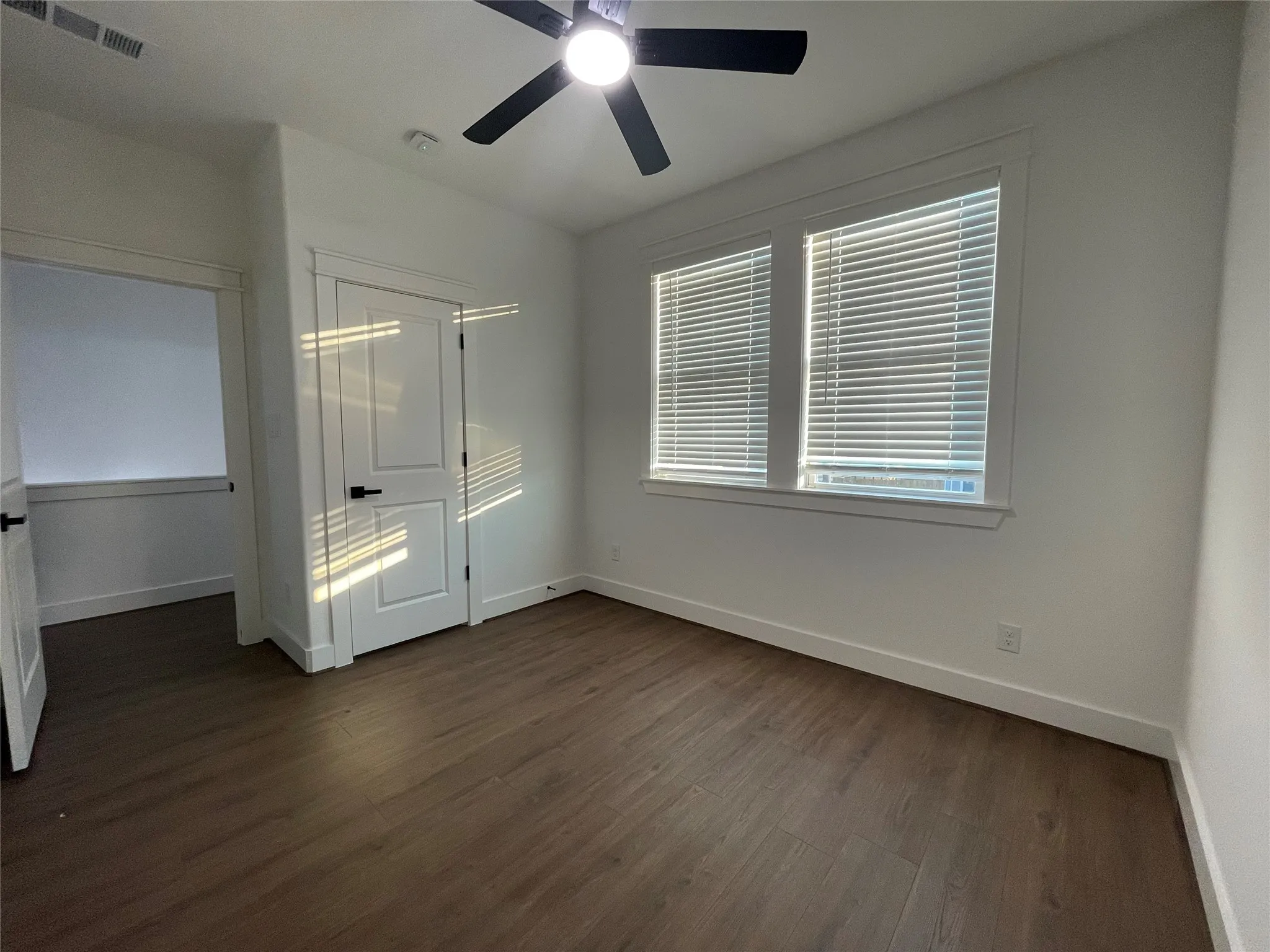 Unfurnished bedroom featuring dark wood finished floors, a ceiling fan, and a closet