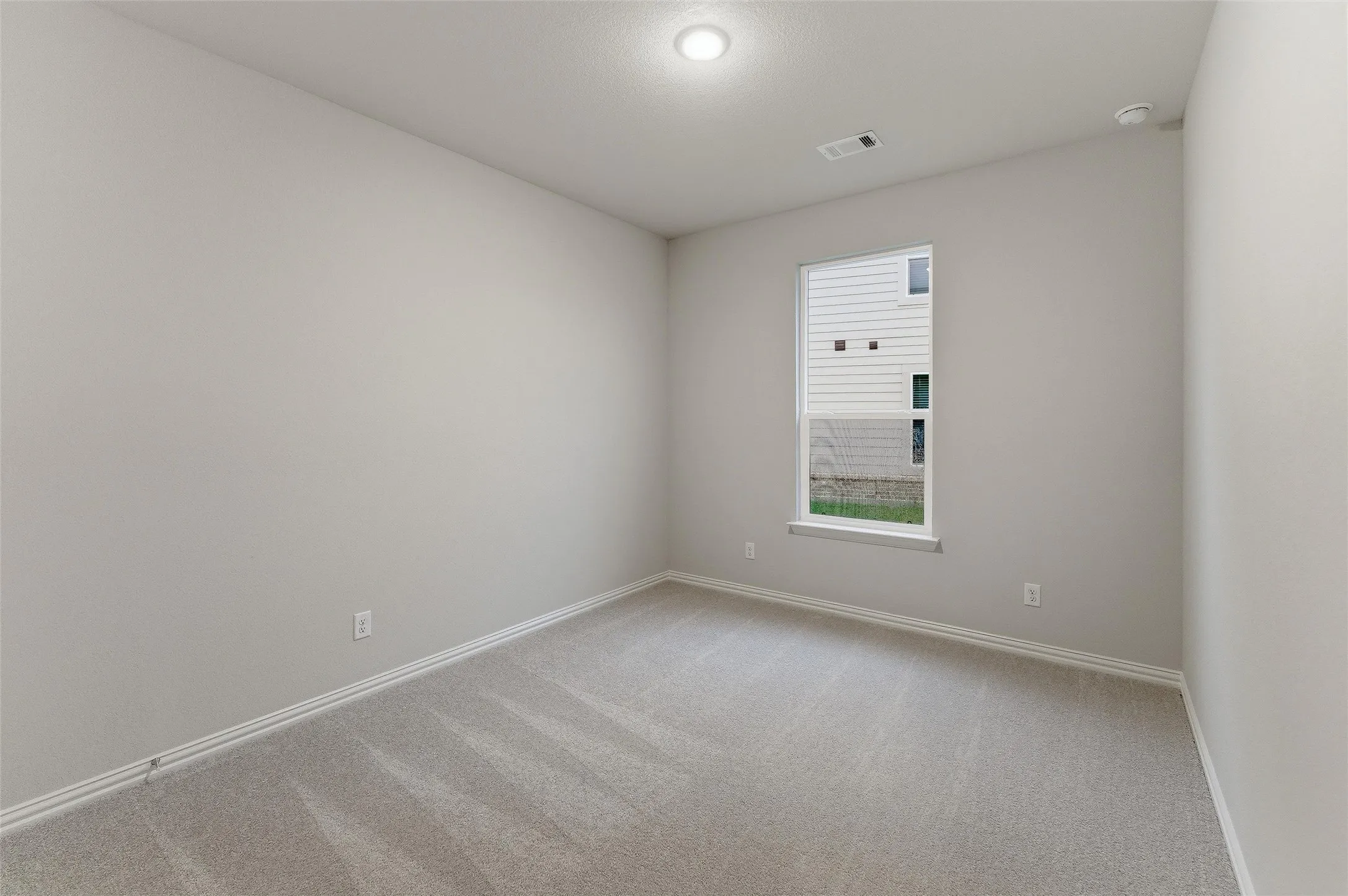 Carpeted room with a single window, recessed lighting, and light-colored walls