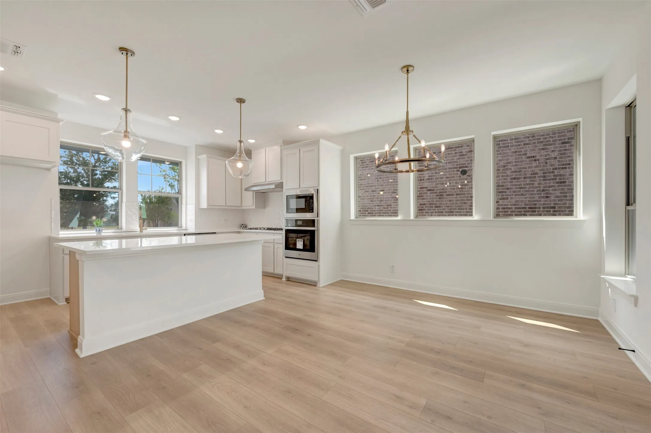 Open-concept kitchen and dining area featuring light wood-finish flooring