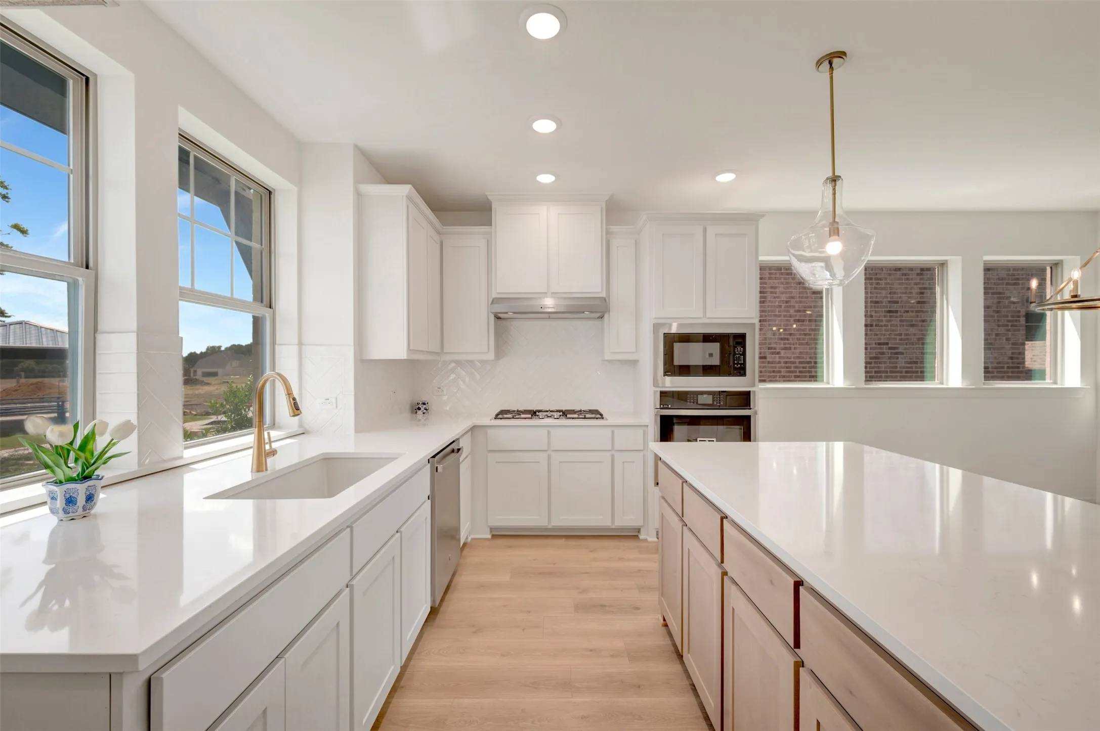 Bright kitchen featuring white cabinetry, light wood-finish flooring, recessed lighting, and a kitchen island with a light-toned countertop