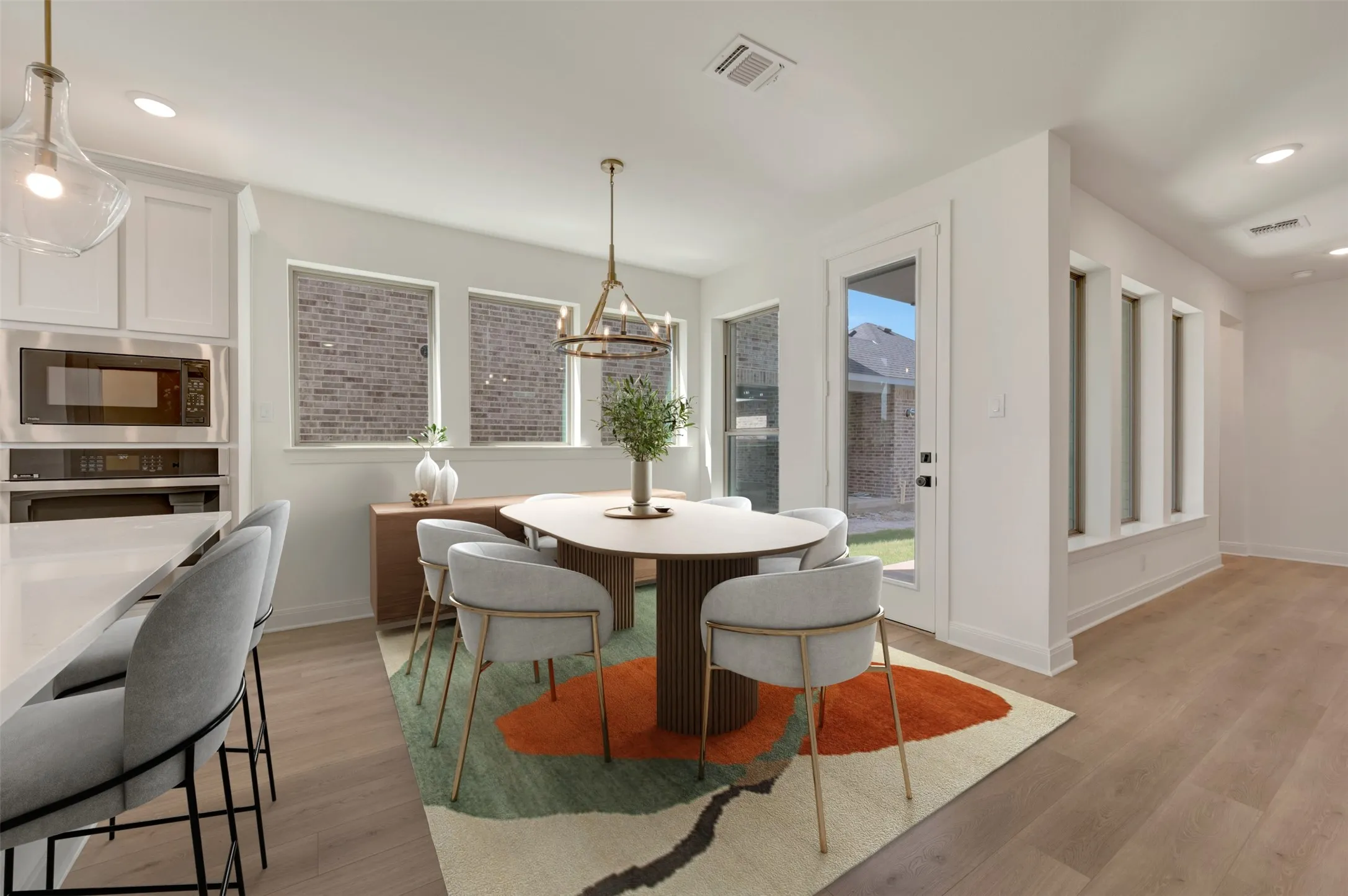 Open-concept dining area featuring wood-finish flooring, a contemporary chandelier, and recessed lighting