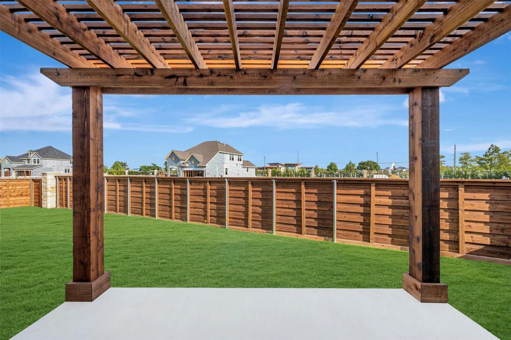 Spacious backyard featuring a new pergola over a concrete patio