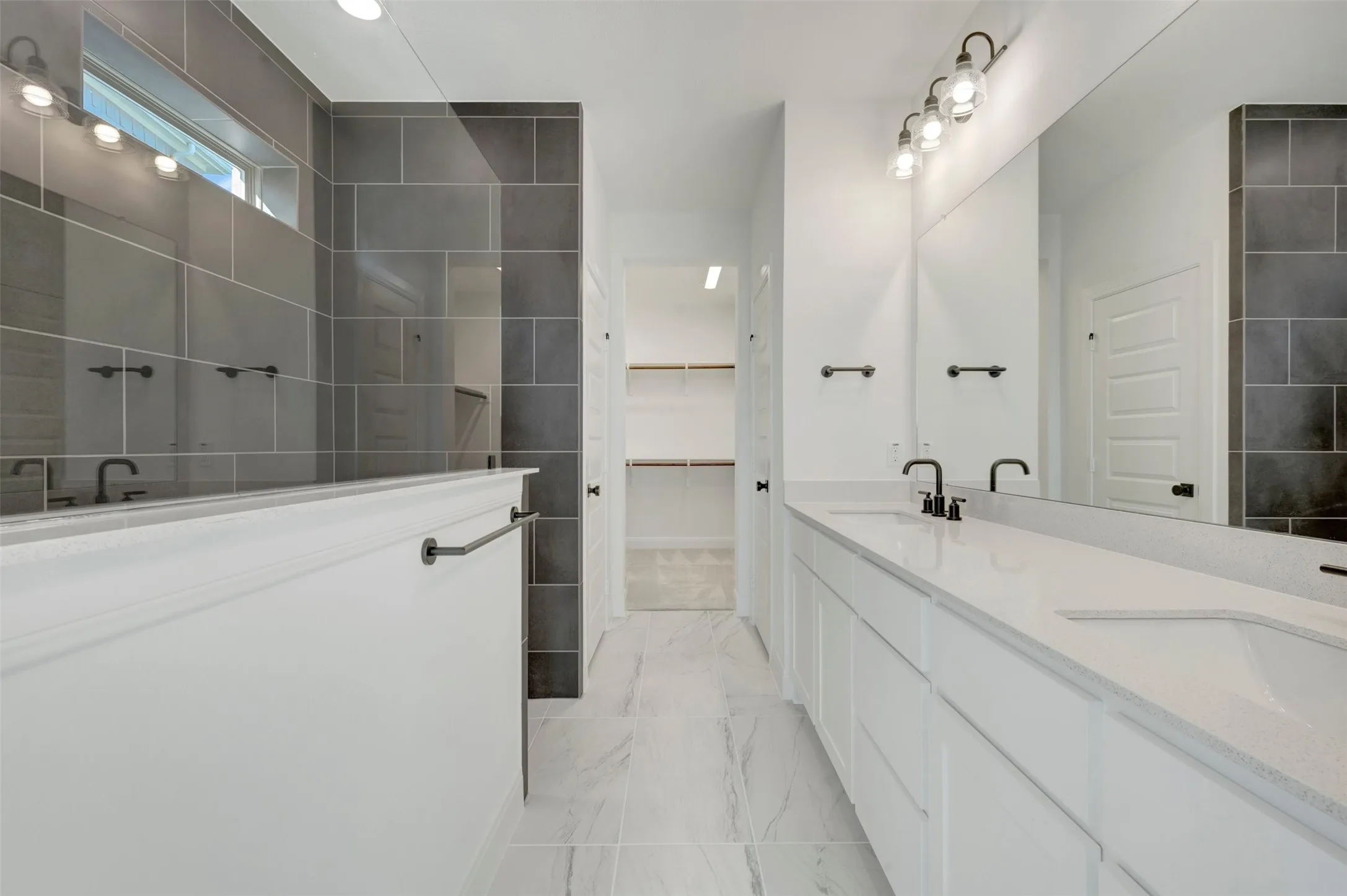 Double vanity with white cabinetry, light-toned countertops, and matte black fixtures