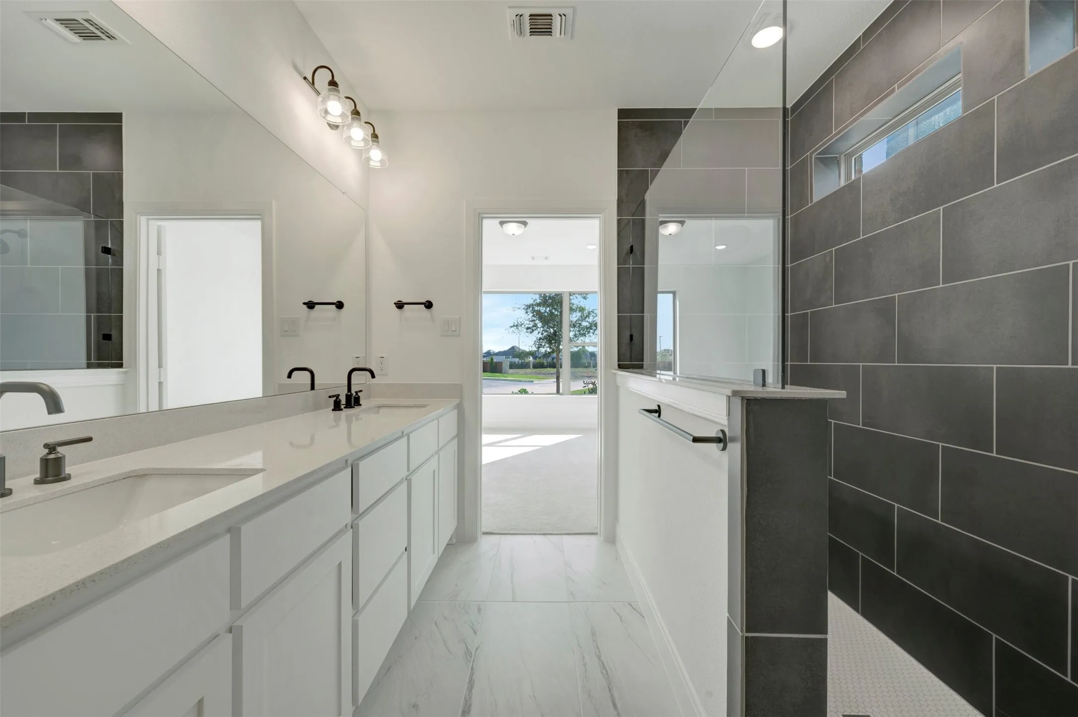 Double vanity featuring undermount sinks, white cabinetry, and a light-toned countertop