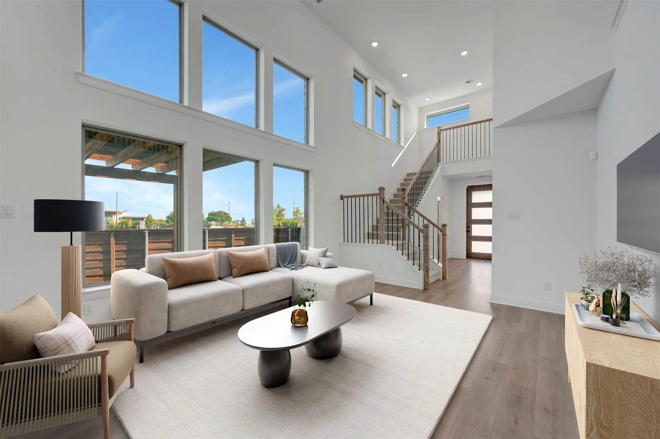 Two-story living area featuring tall windows and wood-finish flooring