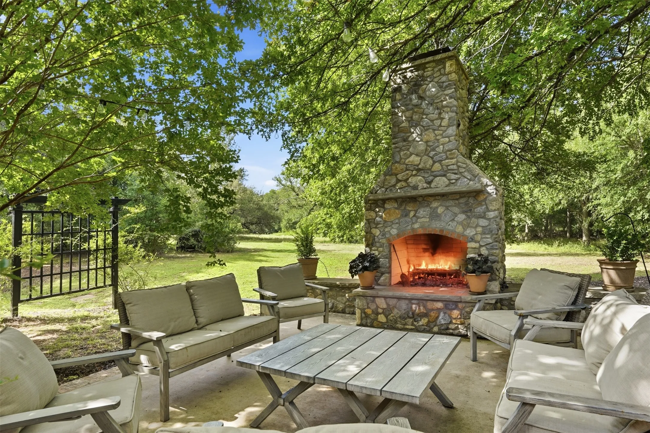 Outdoor living space, string lights and wood burning fireplace.