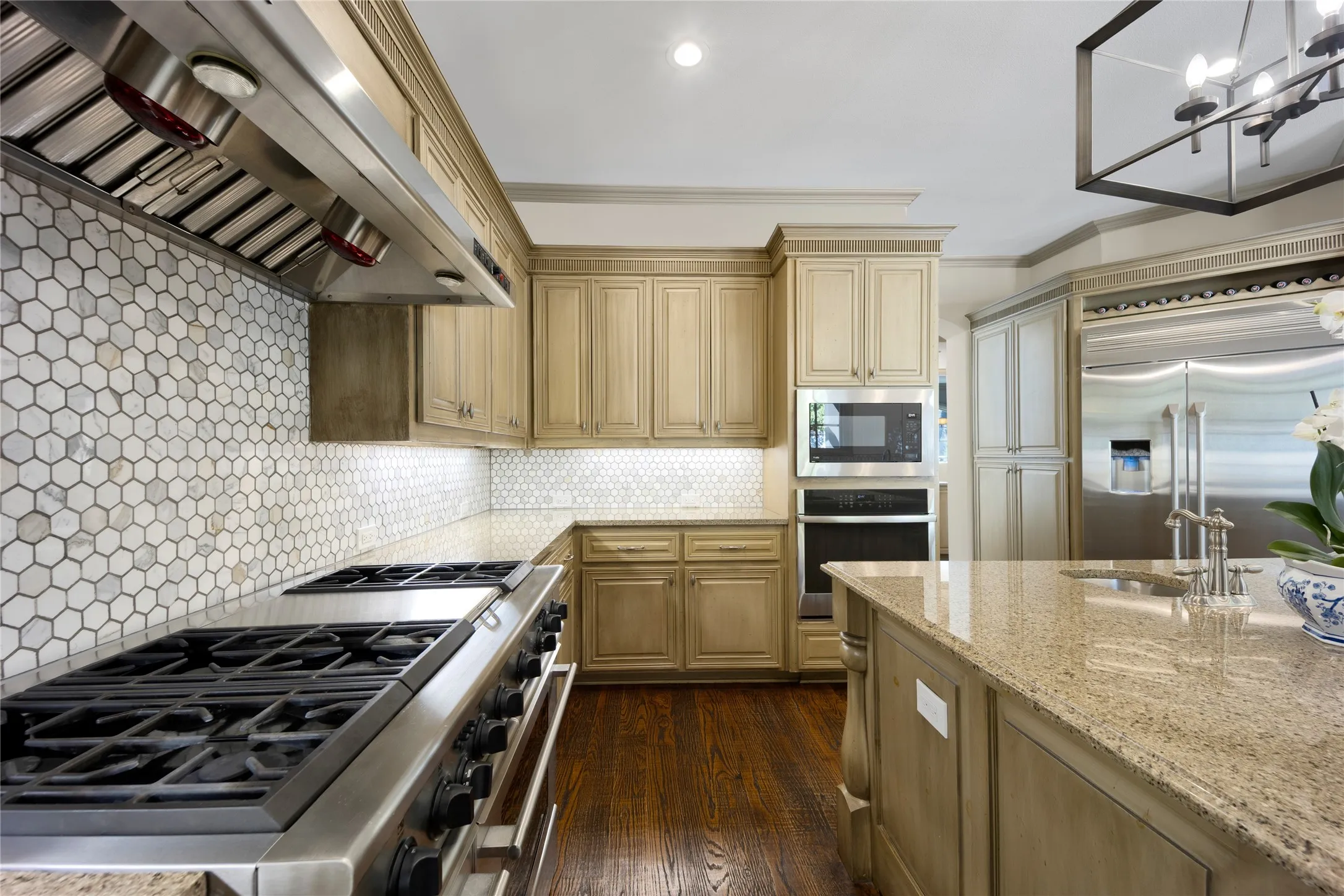 A 6 burner range with griddle and double ovens, microwave and large island are ready for the family chef.