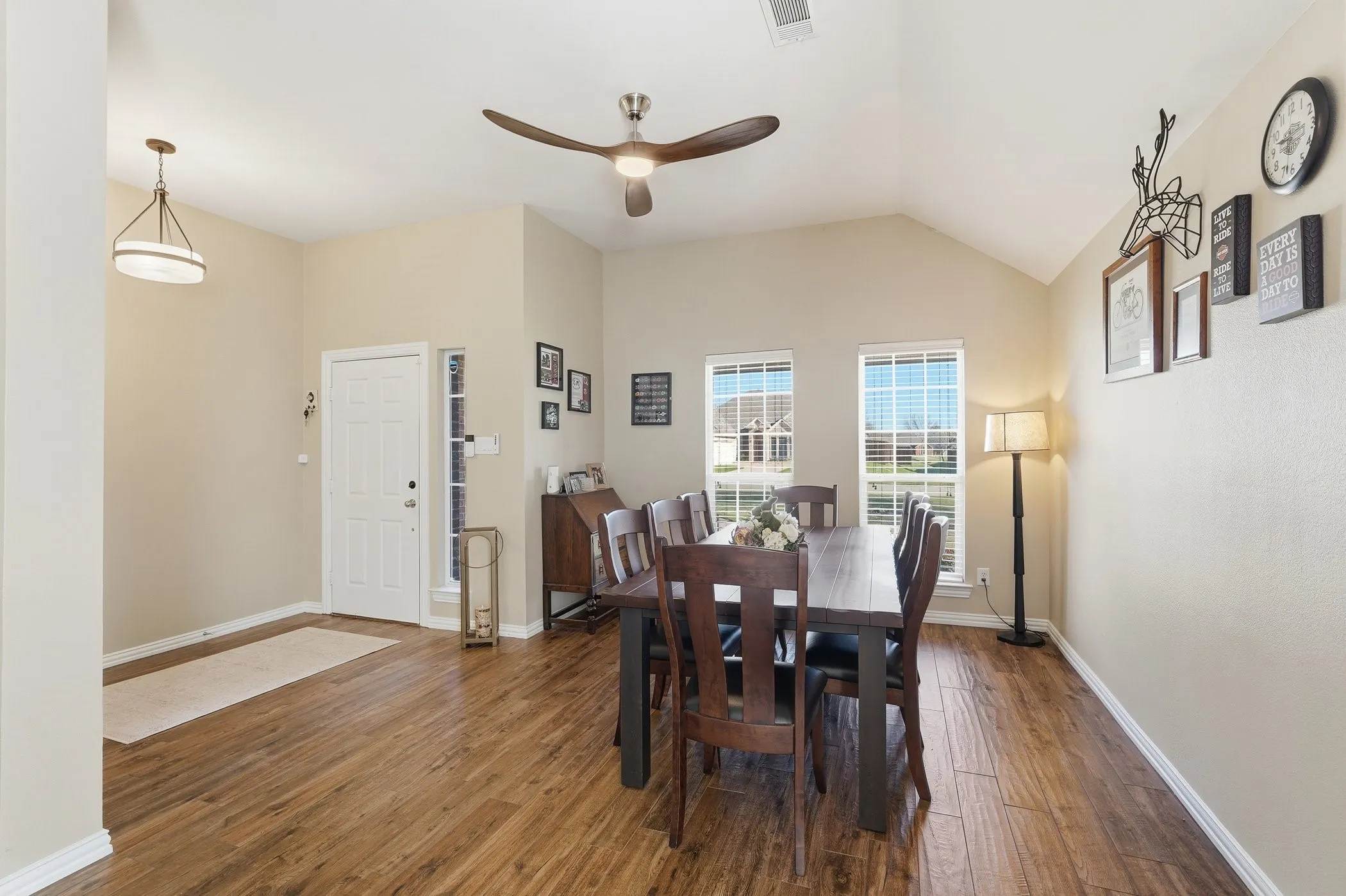 Dining space with dark wood-style floors, lofted ceiling, and ceiling fan