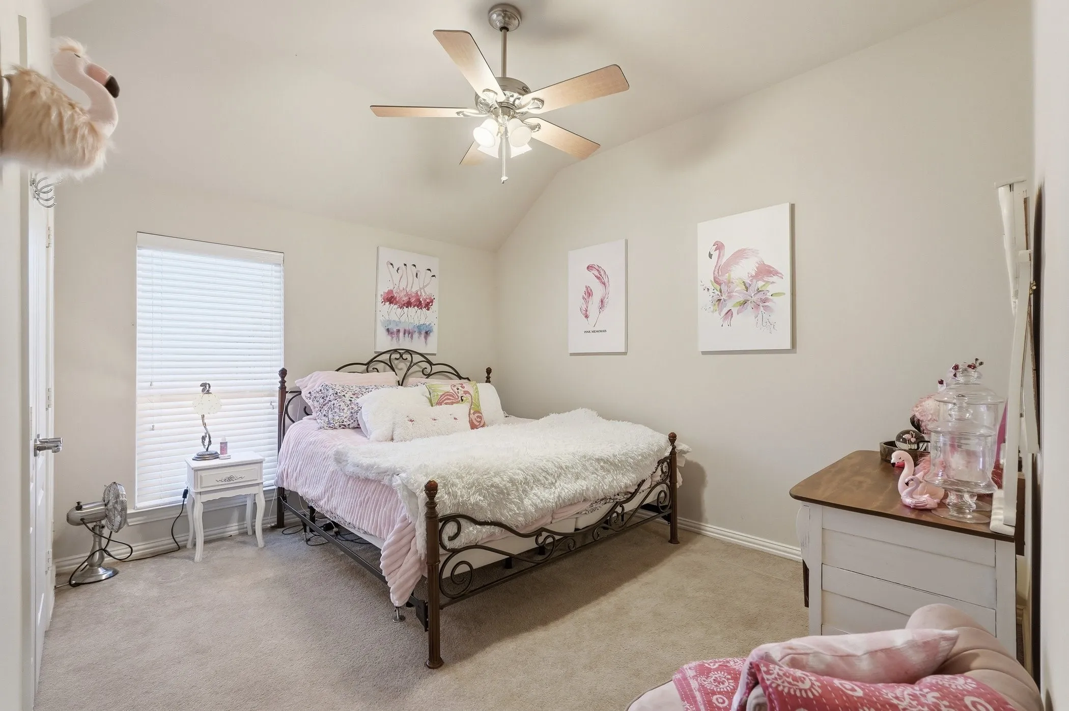 Bedroom with light colored carpet, vaulted ceiling, and ceiling fan