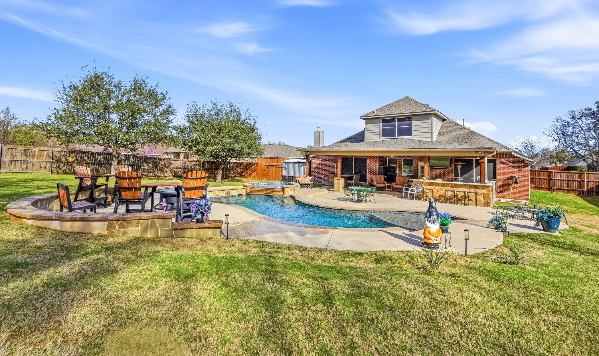 Combined pool / hot tub featuring a fenced backyard and a patio area