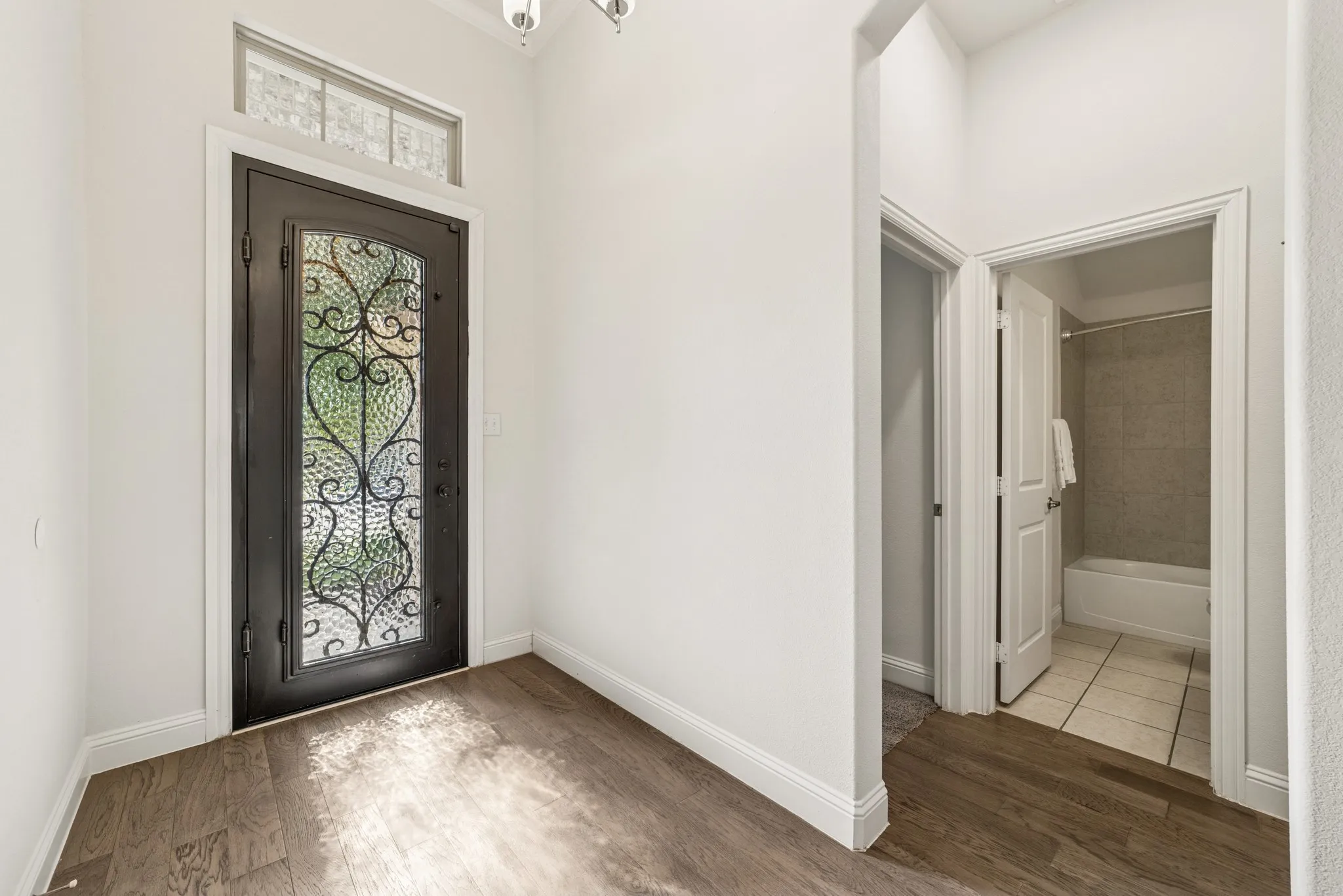 Foyer with wood finished floors and a chandelier