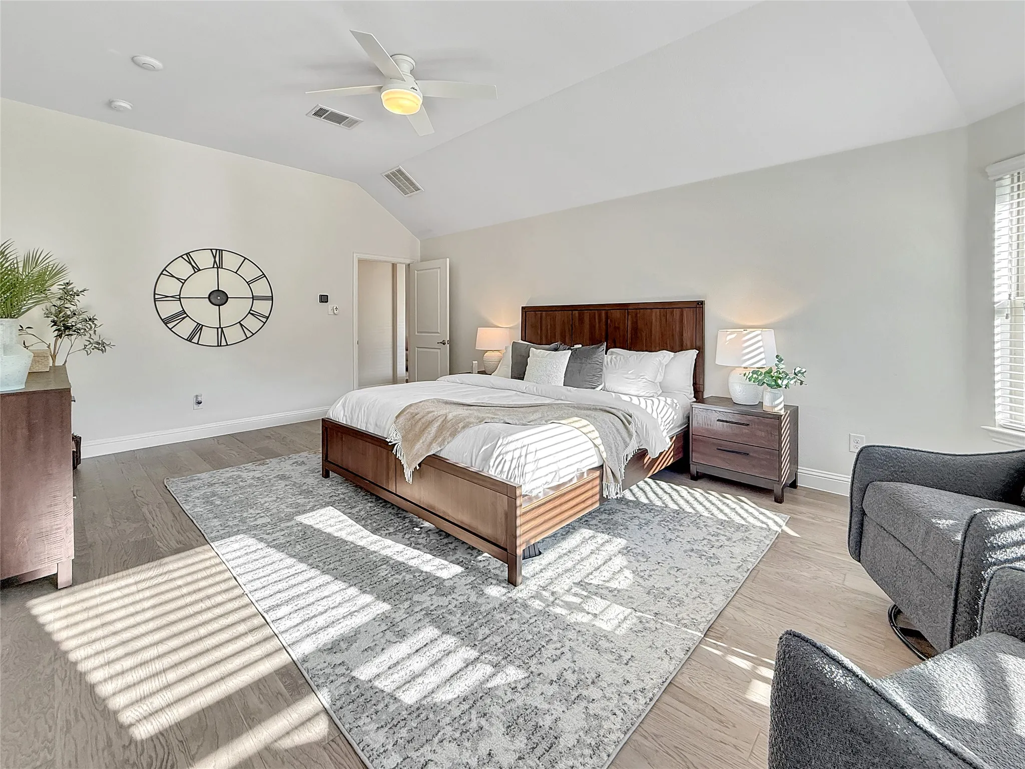 Bedroom featuring light wood-type flooring, vaulted ceiling, and a ceiling fan