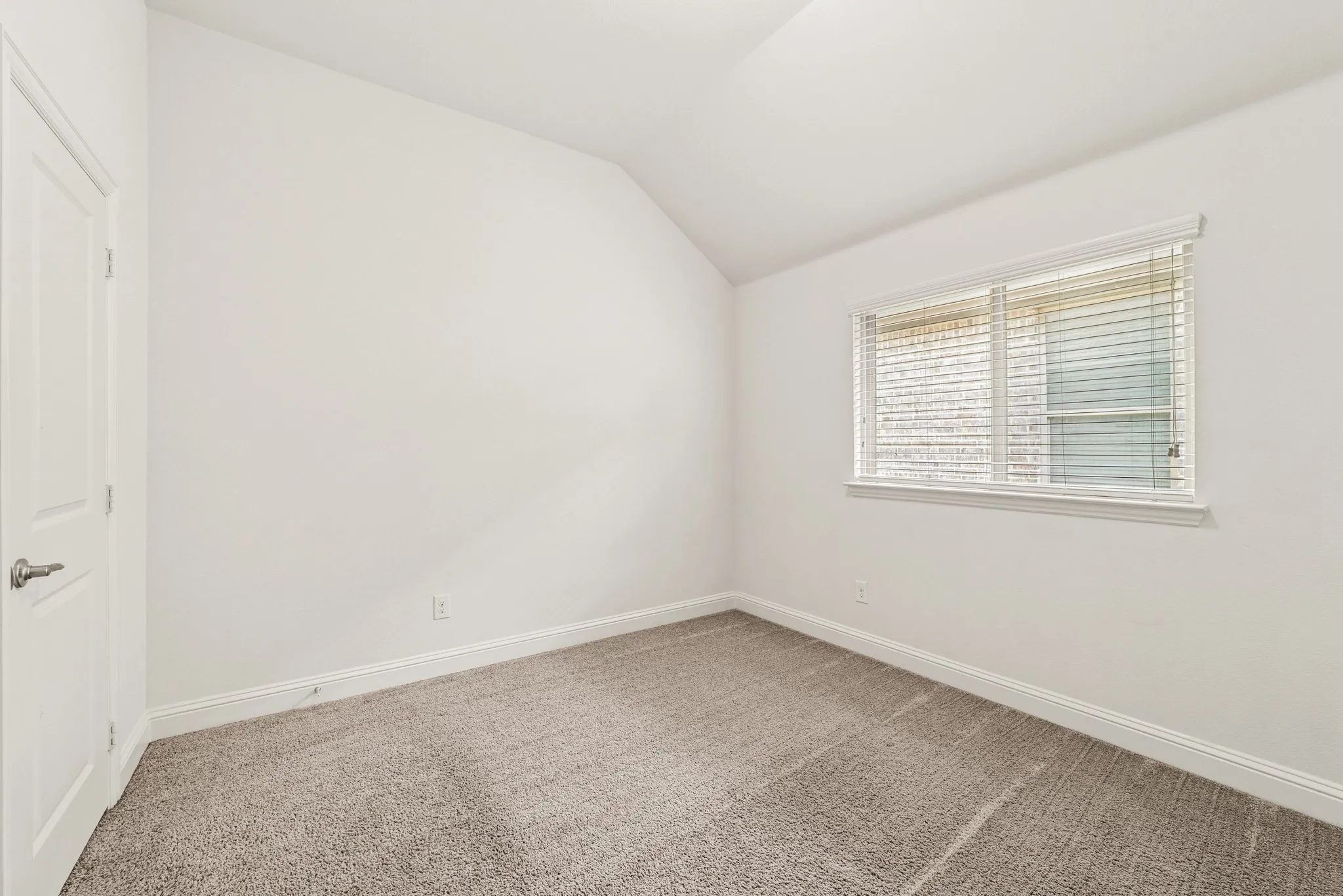 Carpeted bedroom featuring lofted ceiling and baseboards