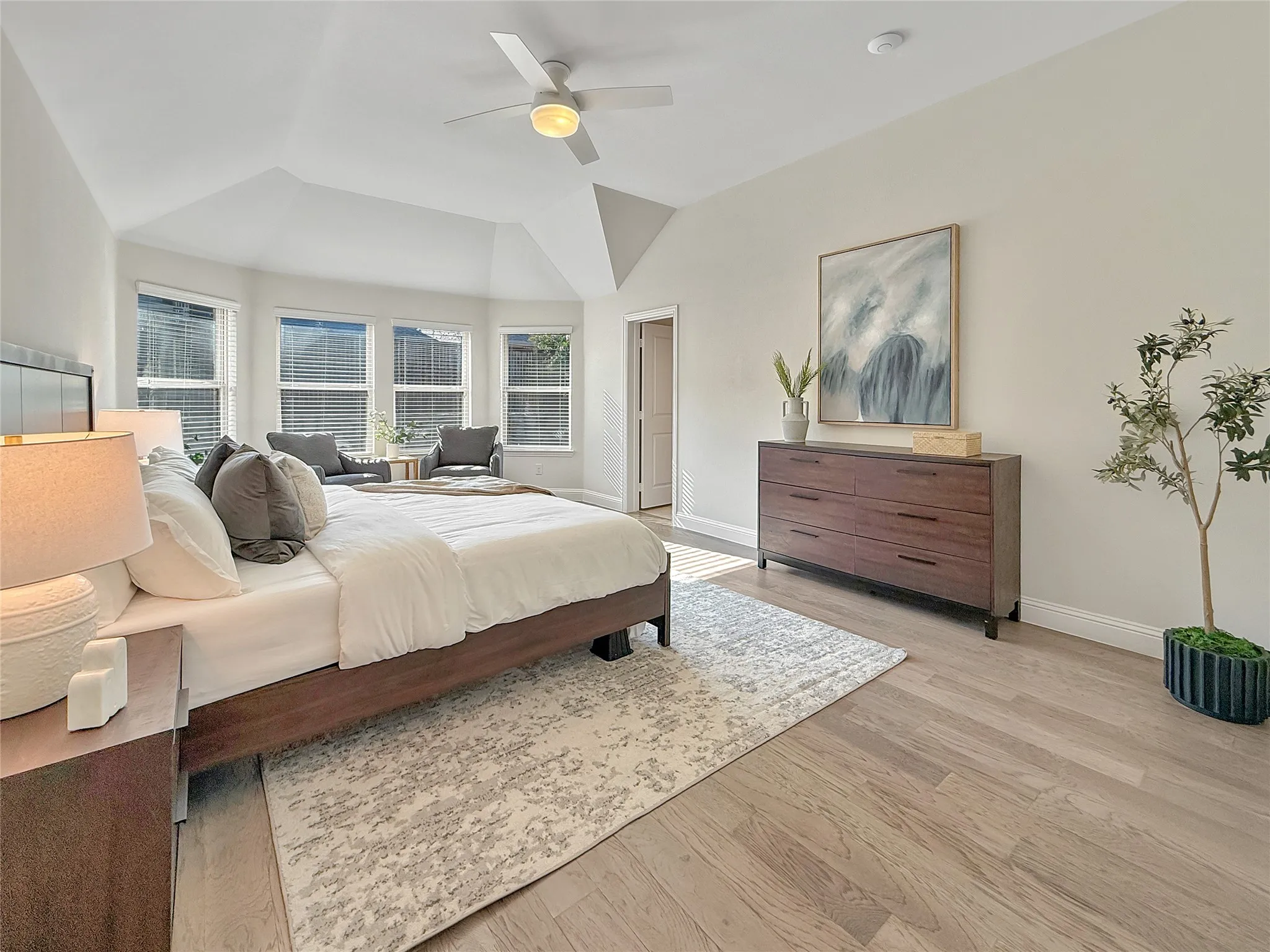Bedroom featuring light wood finished floors, ceiling fan, and lofted ceiling