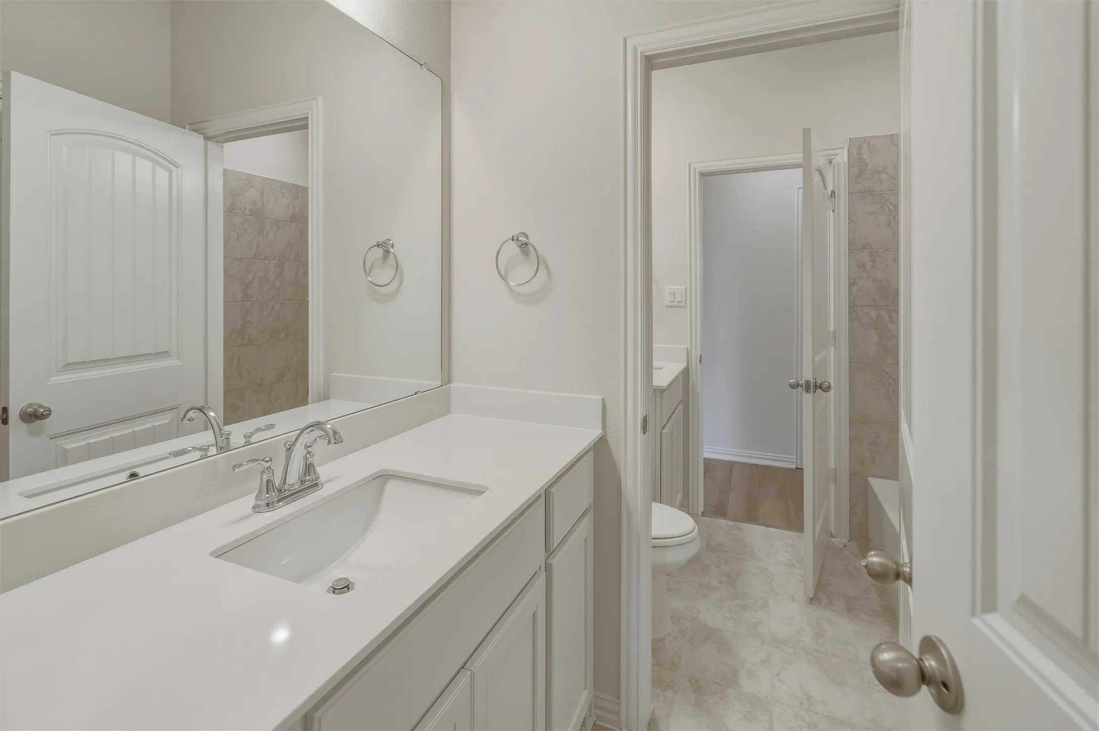 Double vanity with integrated sinks, chrome fixtures, and a full-width mirror