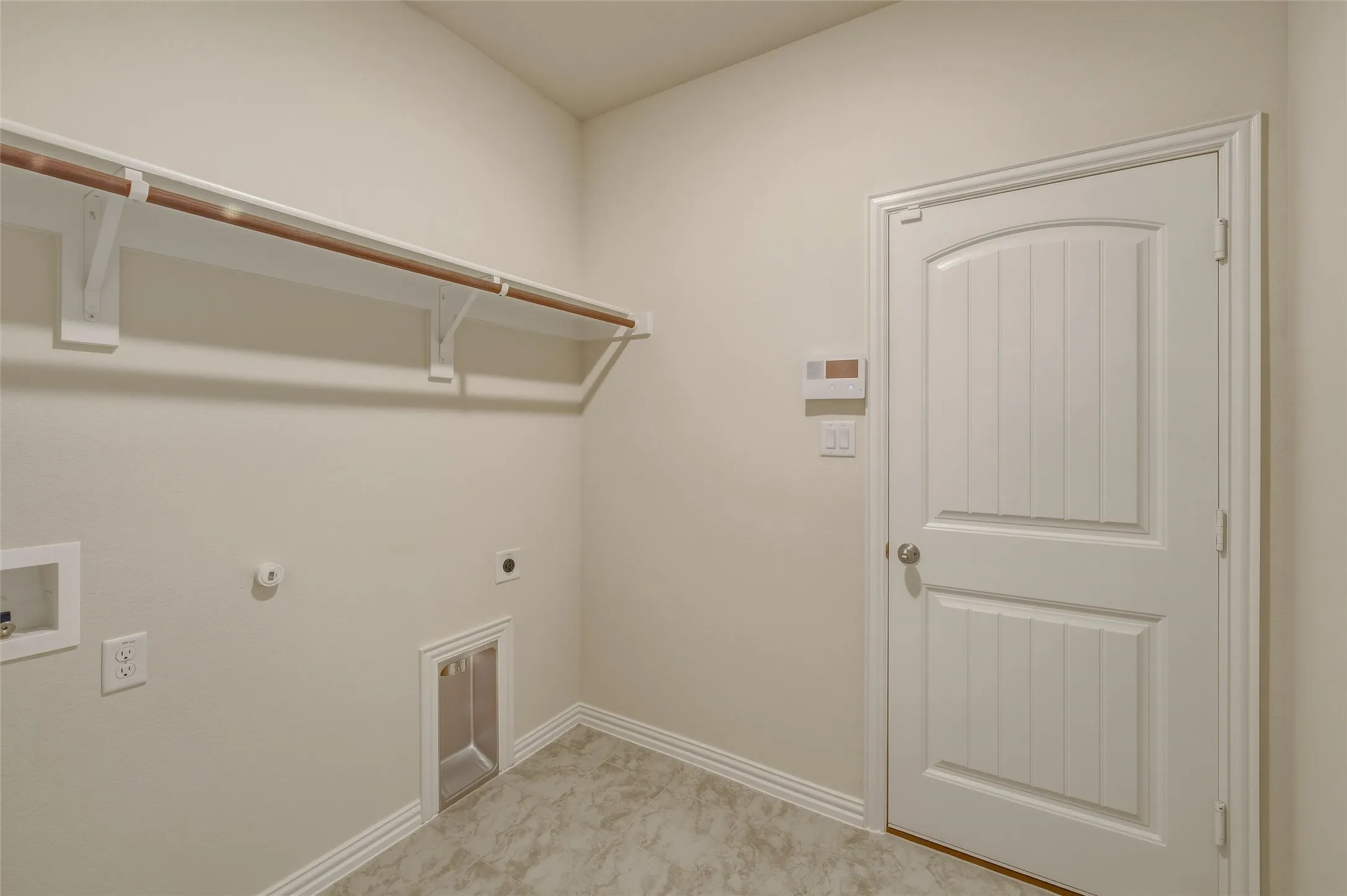 Utility room featuring a hanging rod, integrated dryer vent, washer hookup, and wood-panel door