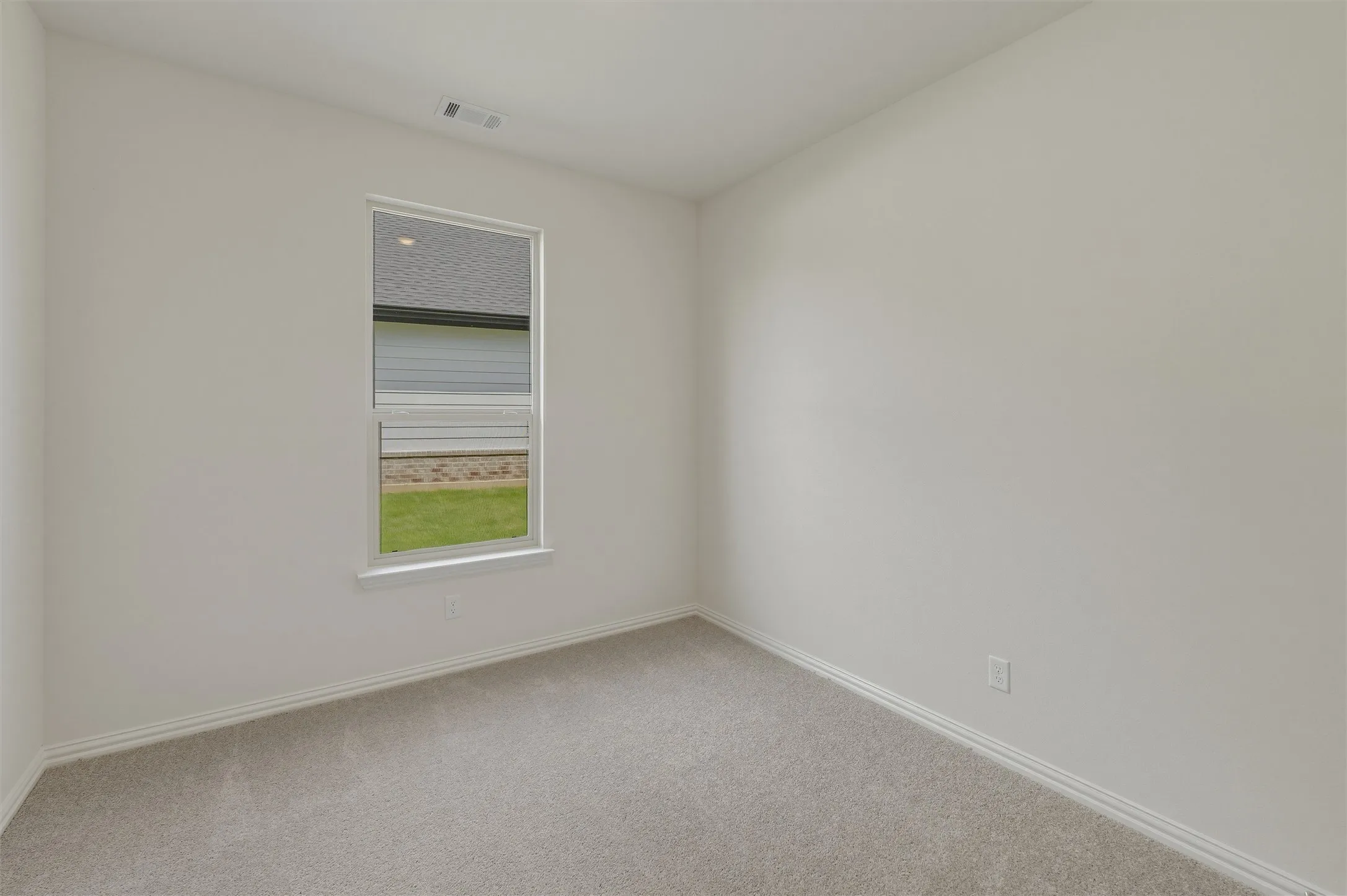 Neutral tone walls with white trim and grey carpeting
