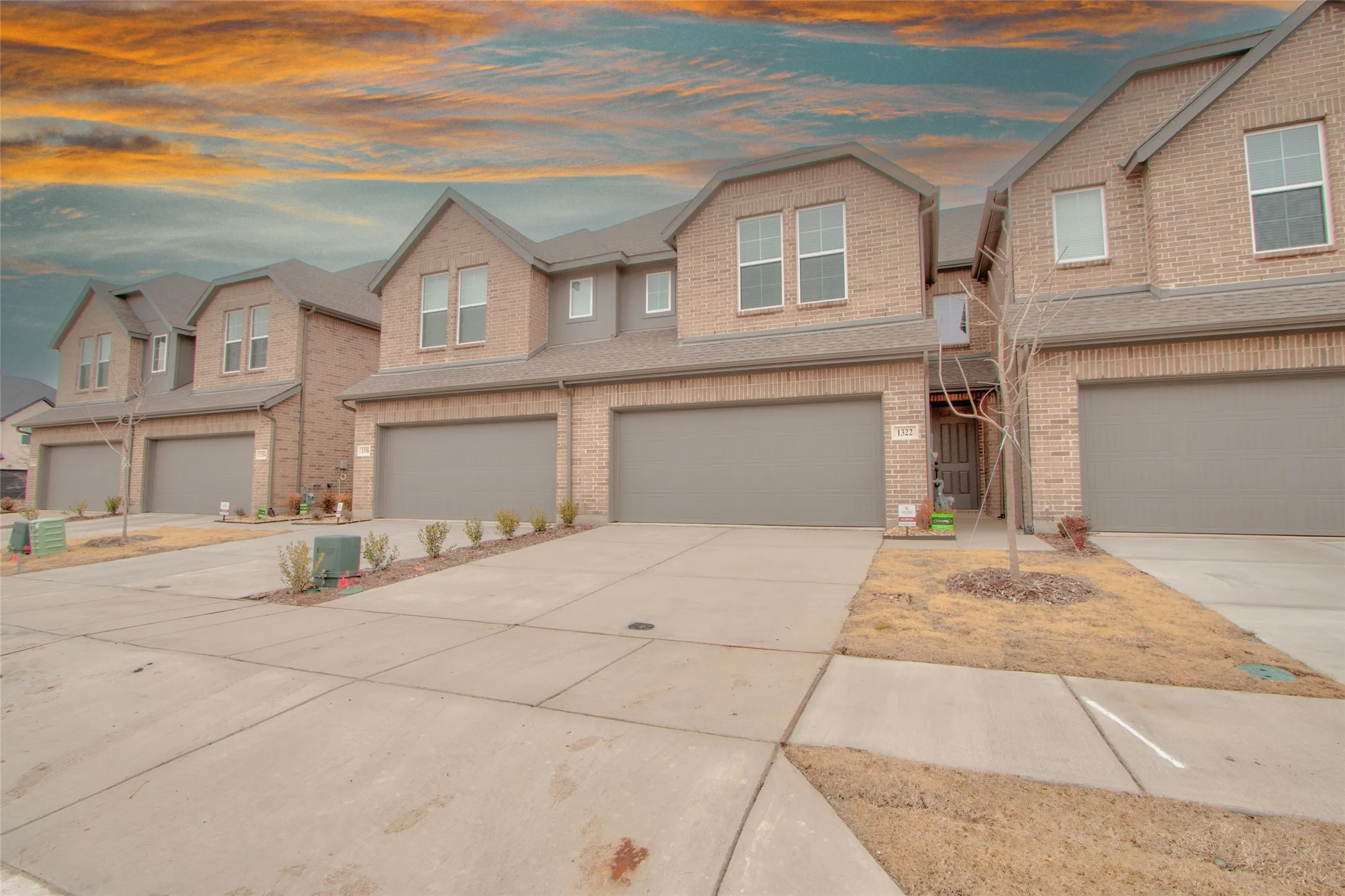 Craftsman house featuring brick siding, an attached garage, and driveway