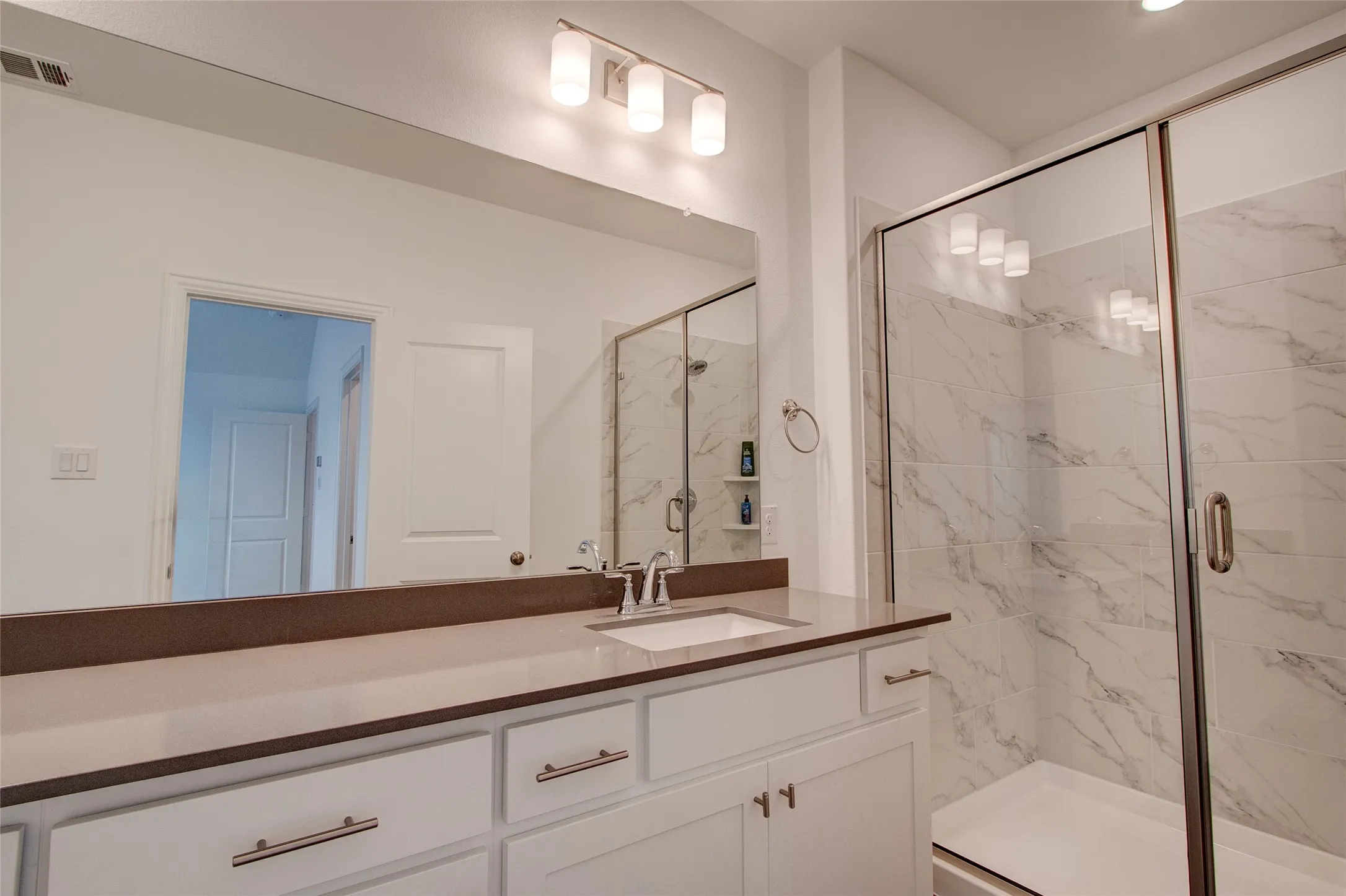 Full bath with a marble finish shower and vanity