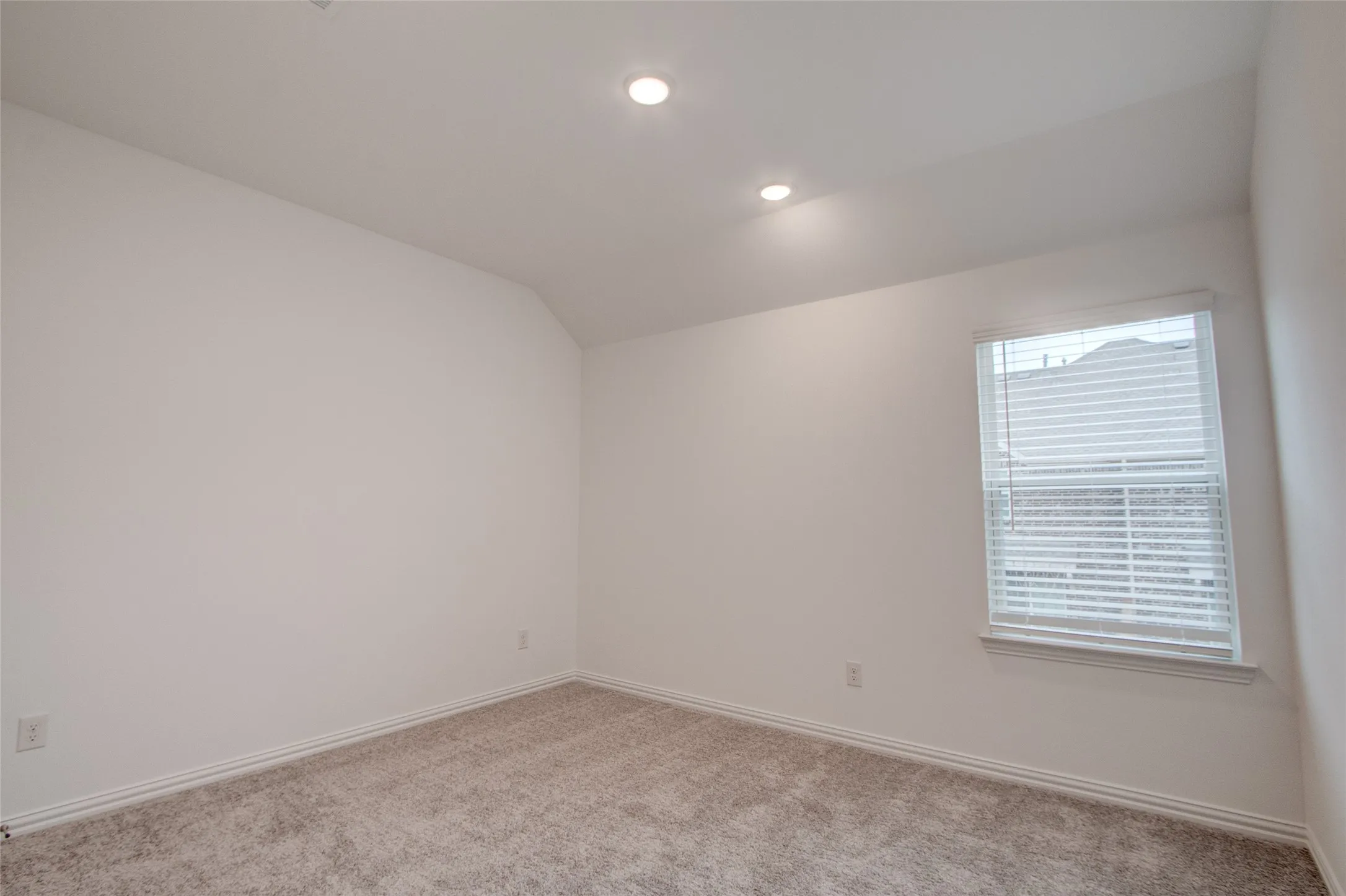 Unfurnished room with lofted ceiling, light colored carpet, and recessed lighting