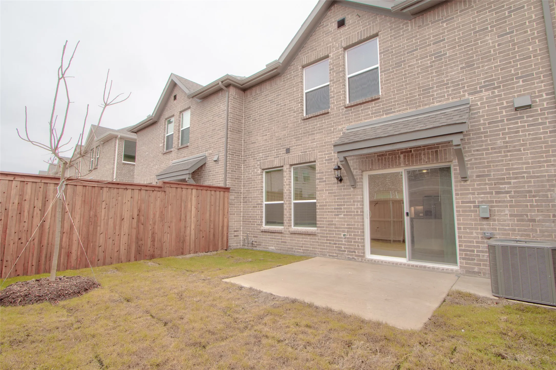Rear view of house with a patio area and brick siding