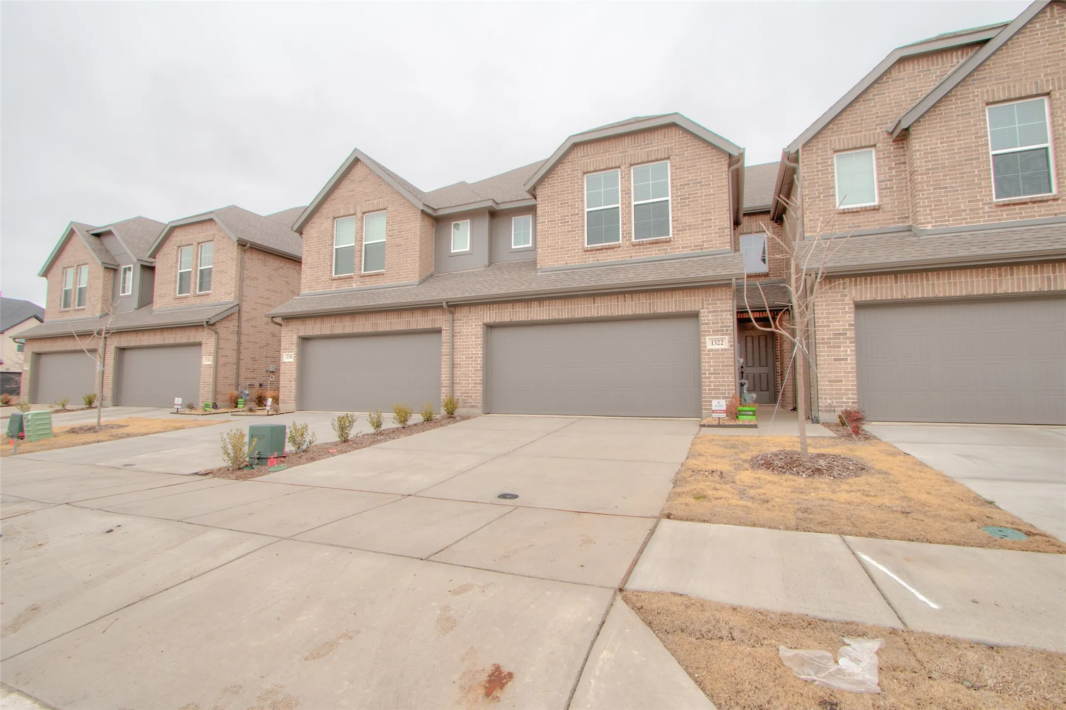 Craftsman-style home with brick siding, a garage, and concrete driveway