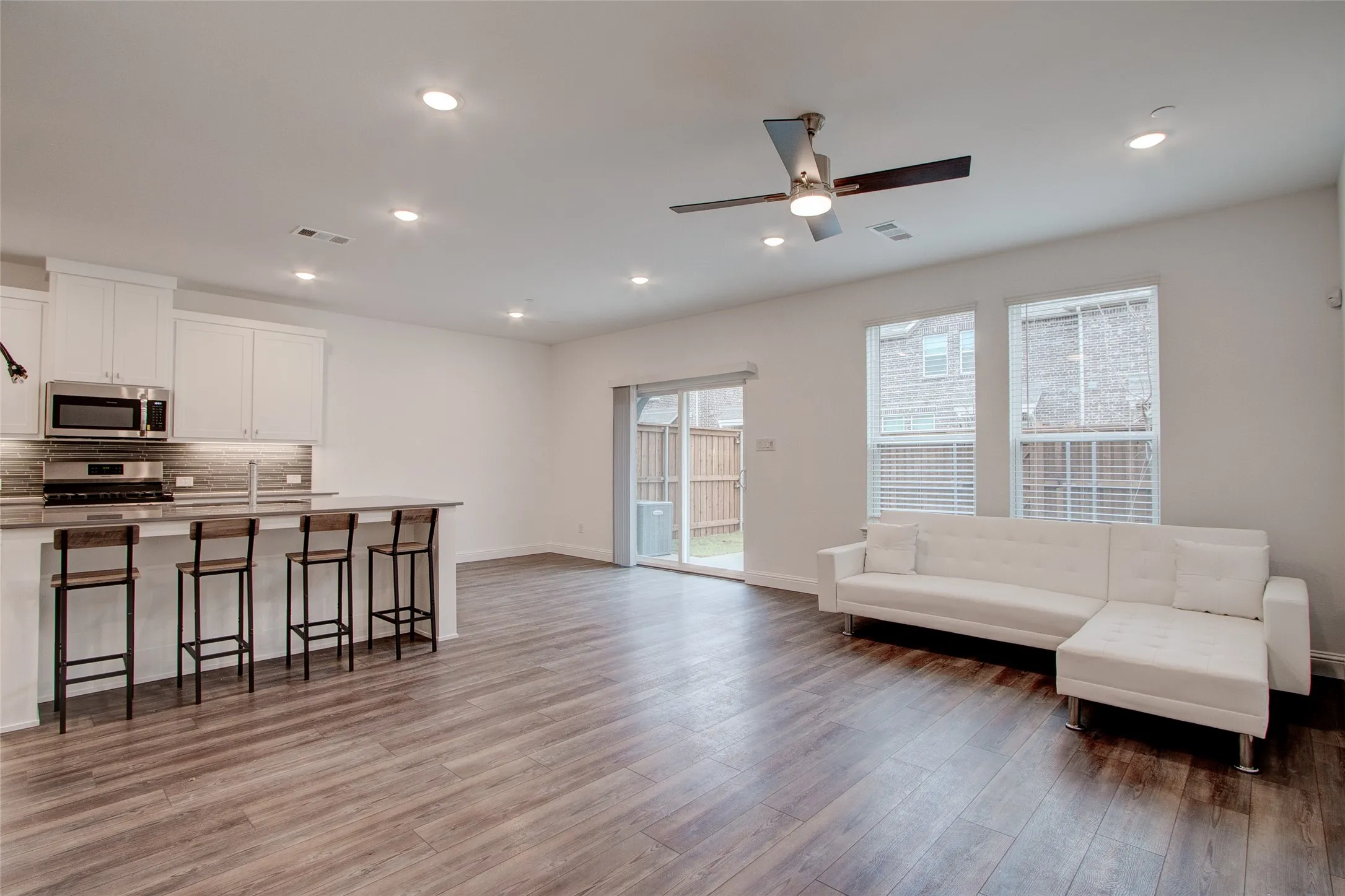 Living room featuring recessed lighting, a ceiling fan, and dark wood-style flooring