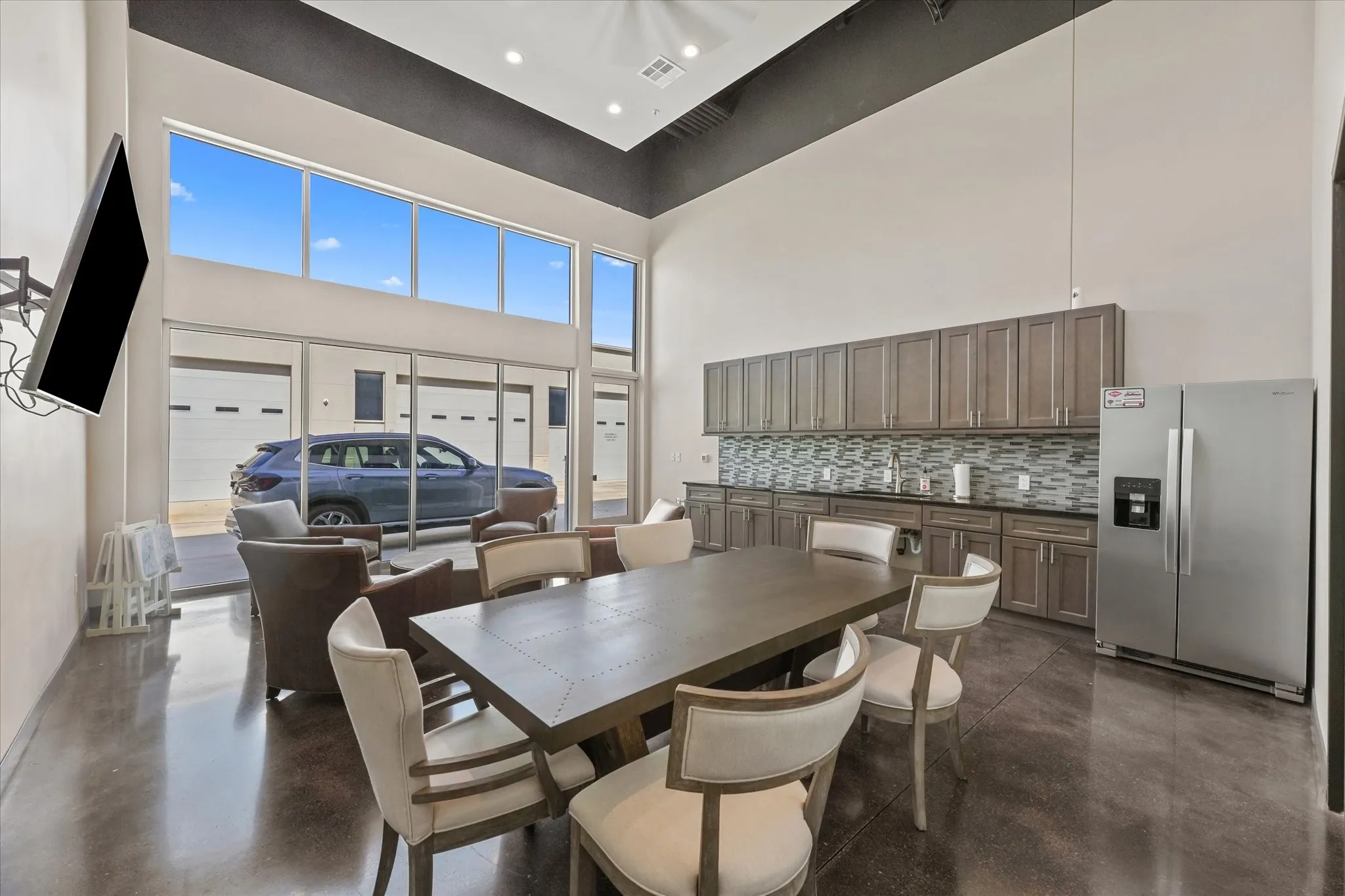Dining space with finished concrete floors and a towering ceiling