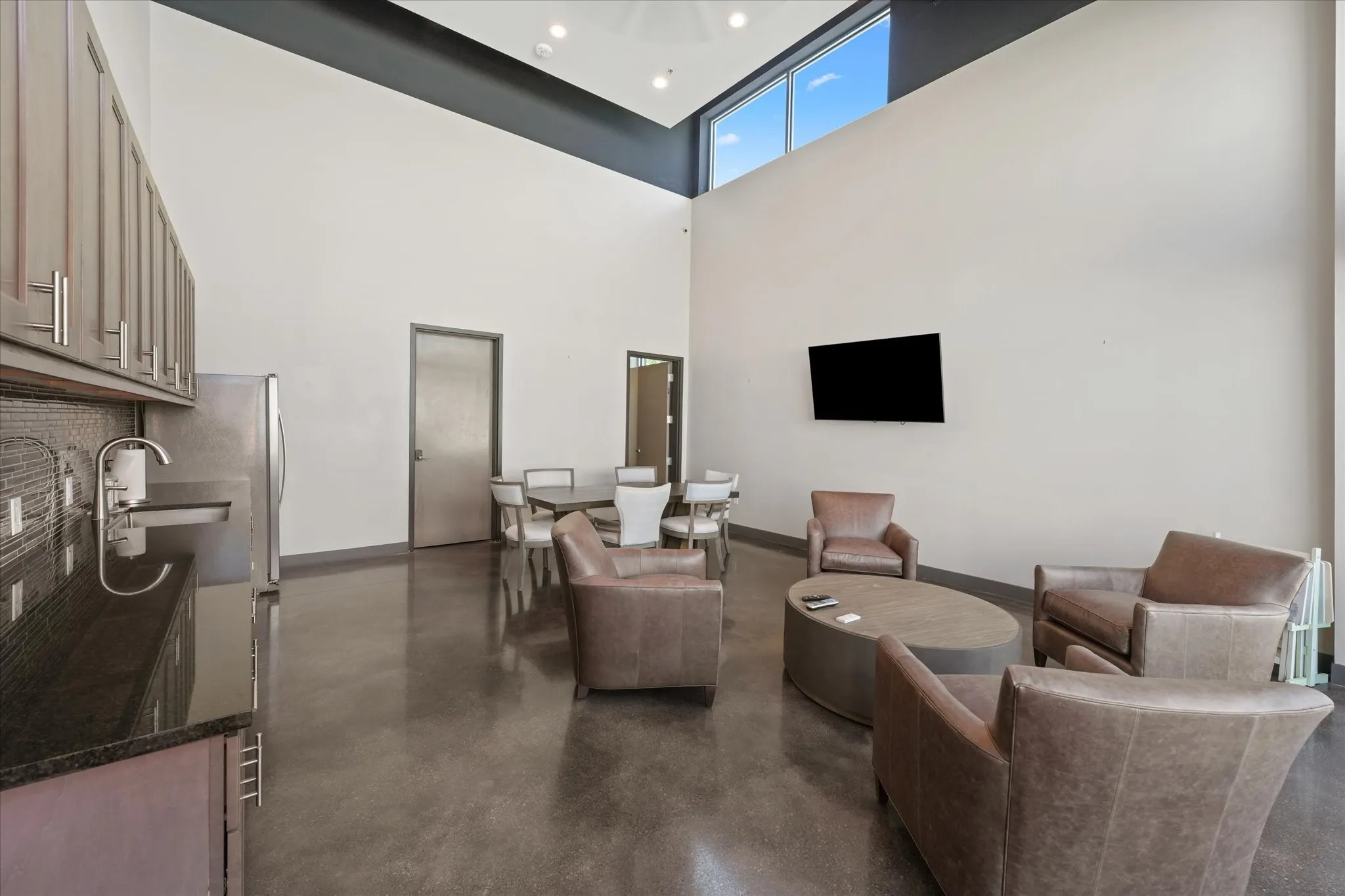 Living area featuring concrete floors and a towering ceiling