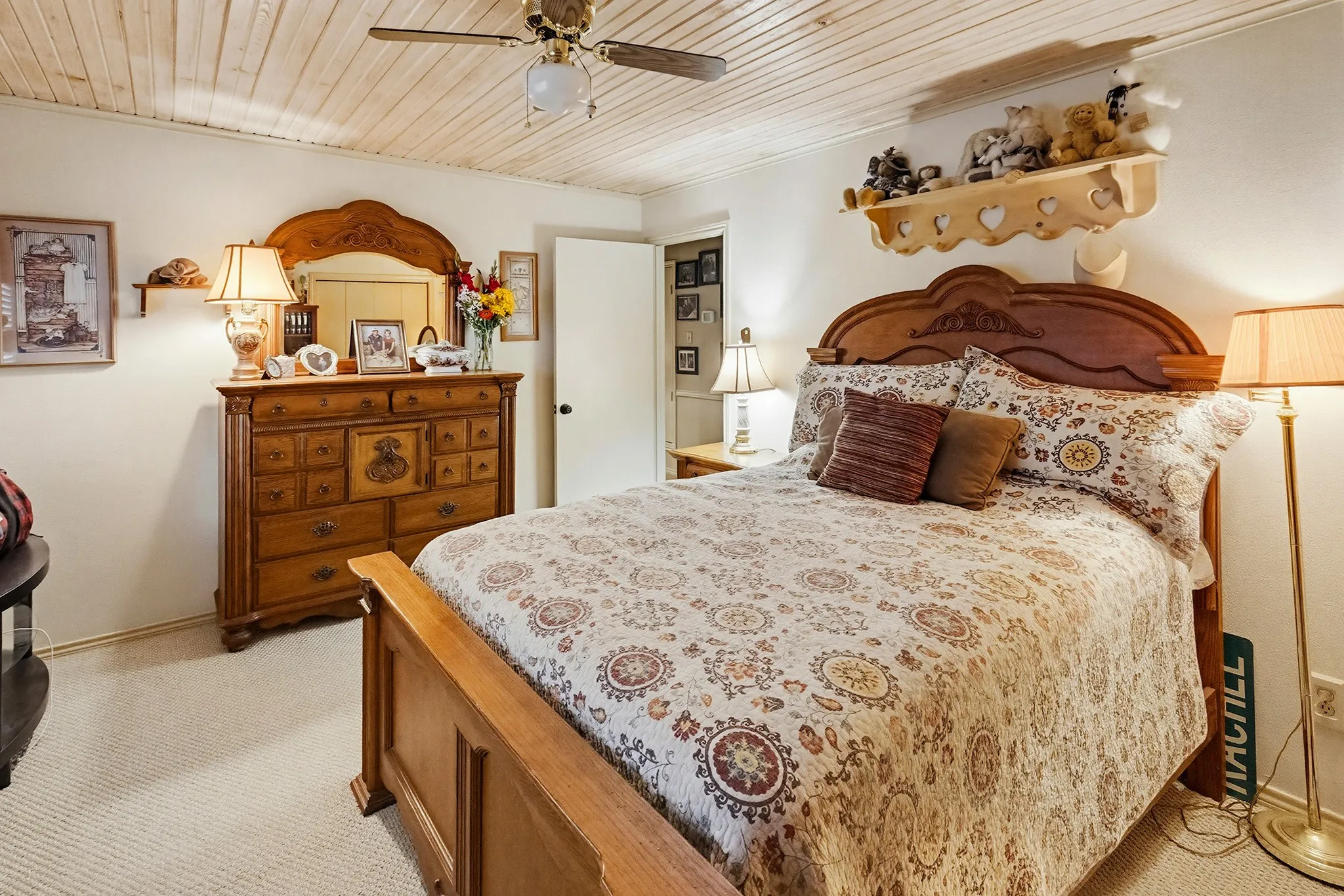 Bedroom with a ceiling fan, light carpet, and wooden ceiling
