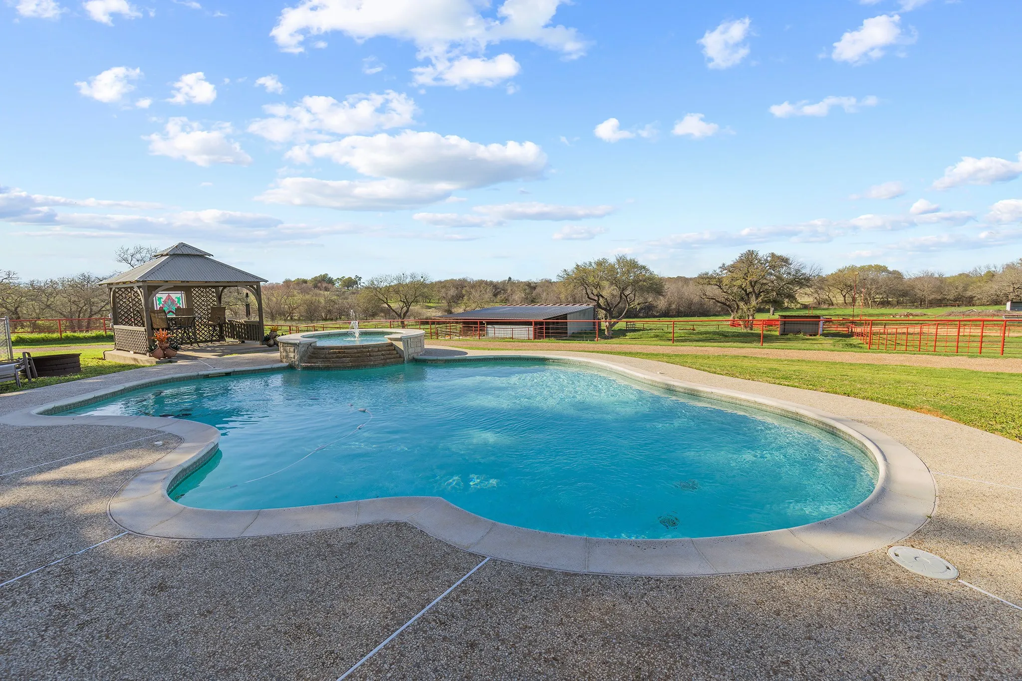 Relaxing pool / spa featuring a gazebo and a patio area